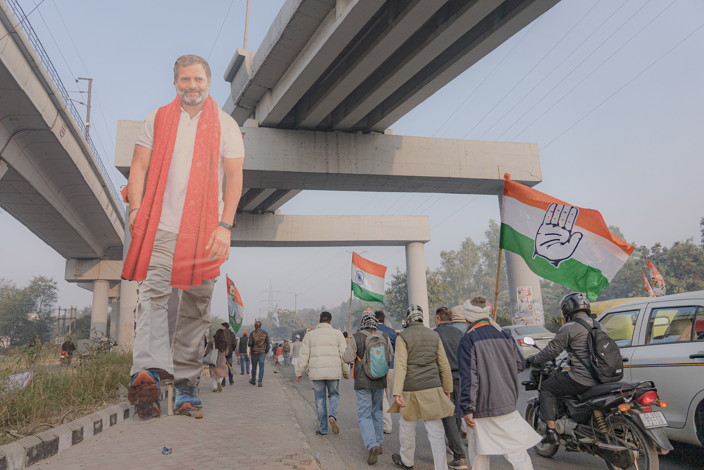 Supporters of Indian National Congress walk by a cut-out of Rahul Gandhi early in the morning to see him during the Bharat Jodo Yatra in New Delhi, India on Dec. 24, 2022. (Ronny Sen for TIME)
