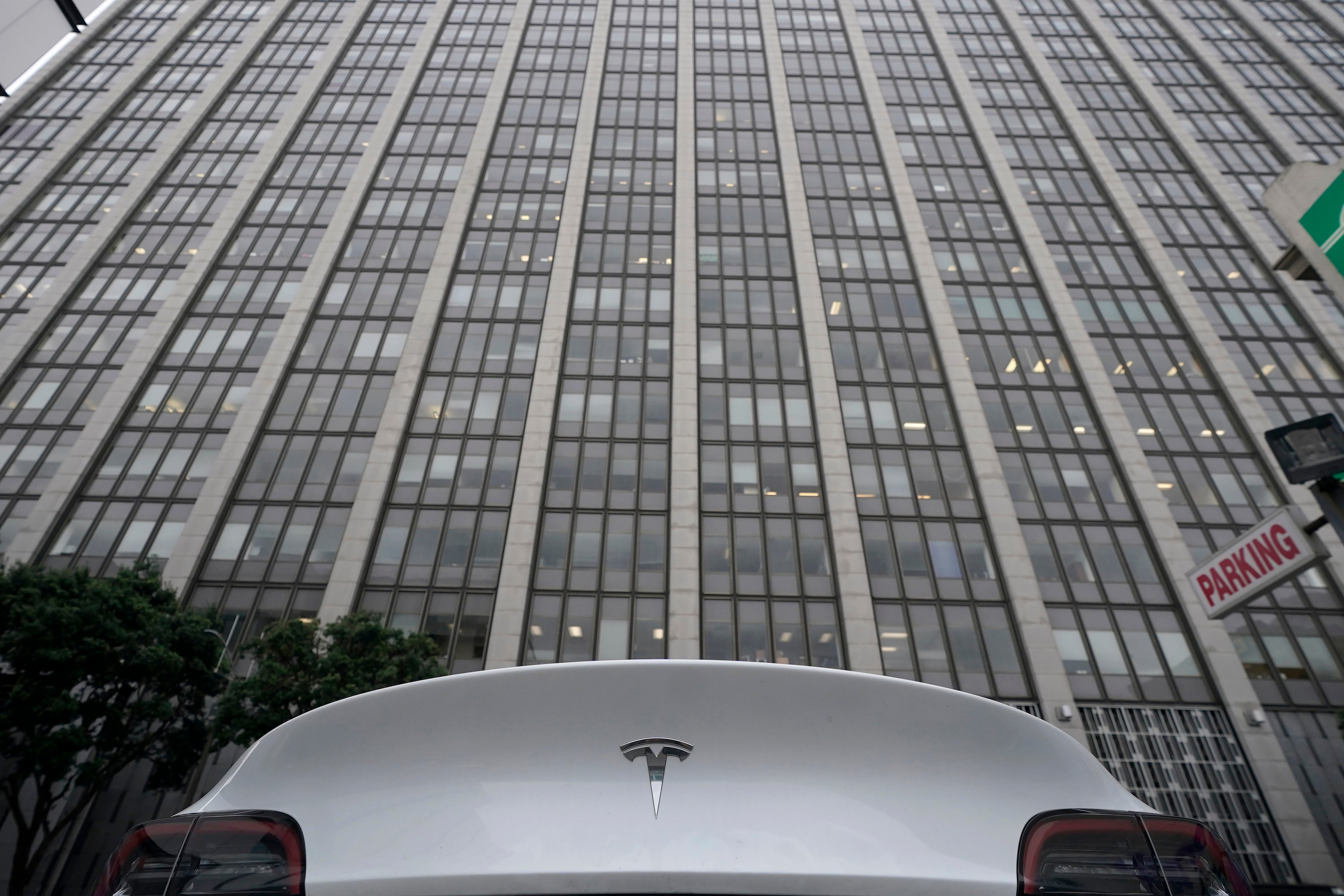 A Tesla car is parked in a lot across the street from a federal courthouse in San Francisco, Wednesday, Jan. 18, 2023. Elon Musk was depicted Wednesday as either a liar who callously jeopardized the savings of "regular people" or a well-intentioned visionary as attorneys delivered opening statements at a trial focused on a Tesla buyout that never happened. (Jeff Chiu–AP)