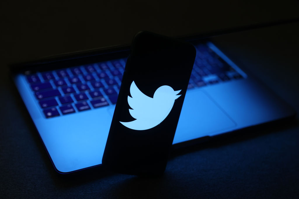 Twitter logo displayed on a phone screen and a laptop are seen in this illustration photo taken in Krakow, Poland on November 27, 2022. (Jakub Porzycki–NurPhoto/Getty Images)