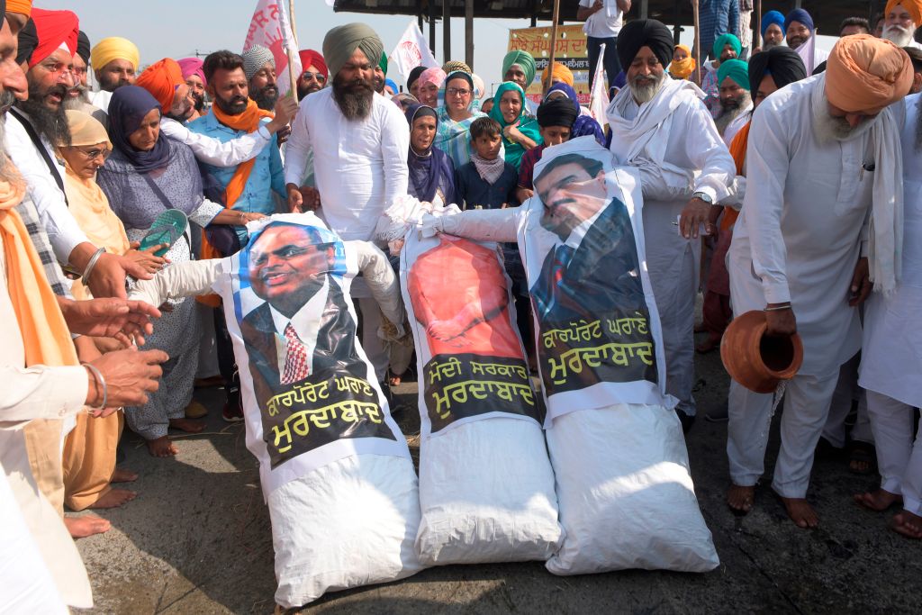 Farmers shout slogans before burning effigies of Narendra Modi, Mukesh Ambani, Gautam Adani, to protest against corporate businesses following the recent passing of agriculture bills in the parliament. (Narinder Nanu—AFP/Getty Images)