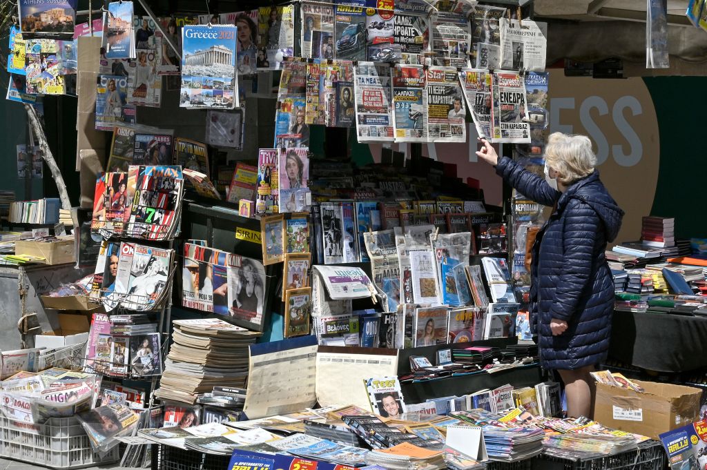 A woman reads newspaper headlines in Athens on April 10, 2021. (Louisa Gouliamaki—AFP/Getty Images)