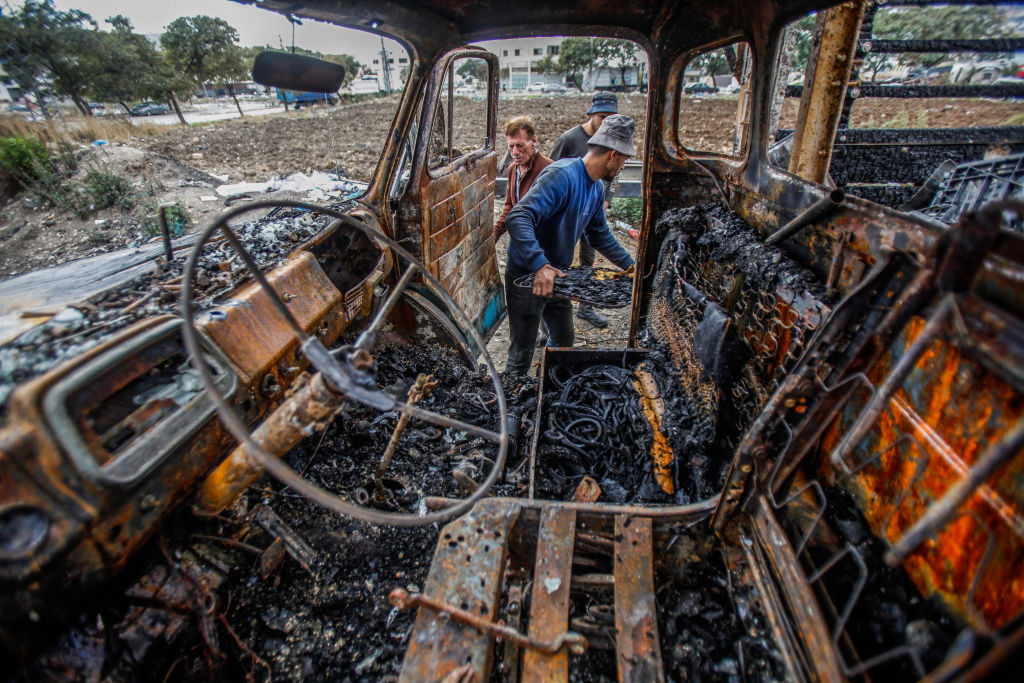 Palestinians inspect a destroyed truck after it was set on fire by Jewish settlers during an attack in the occupied West Bank in November 2022. (Nasser Ishtayeh—SOPA Images/LightRocket/Getty Images)