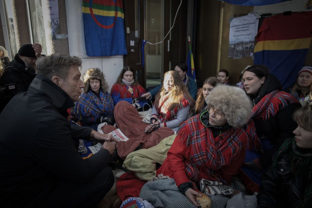Norway's Oil and Energy Minister Terje Aasland speaks to young climate protesters from the "Nature and Youth" and "Norwegian Samirs Riksforbund Nuorat" groups who block the entrance of Norway's Energy Ministry on February 28, 2023. (Oliver Morin—AFP/Getty Images)