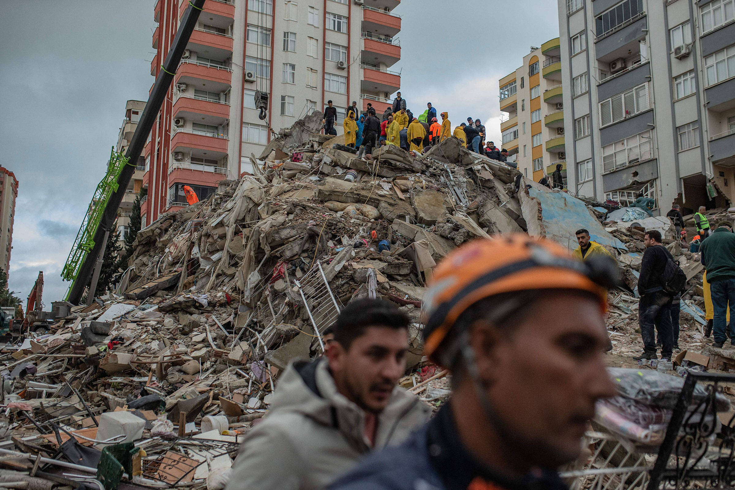 Rescuers search for victims and survivors amidst the rubble of a building that collapsed in Adana, Turkey, on Feb. 6, 2023, after a 7.8-magnitude earthquake struck the country's south-east. (Can Erok—AFP/Getty Images)