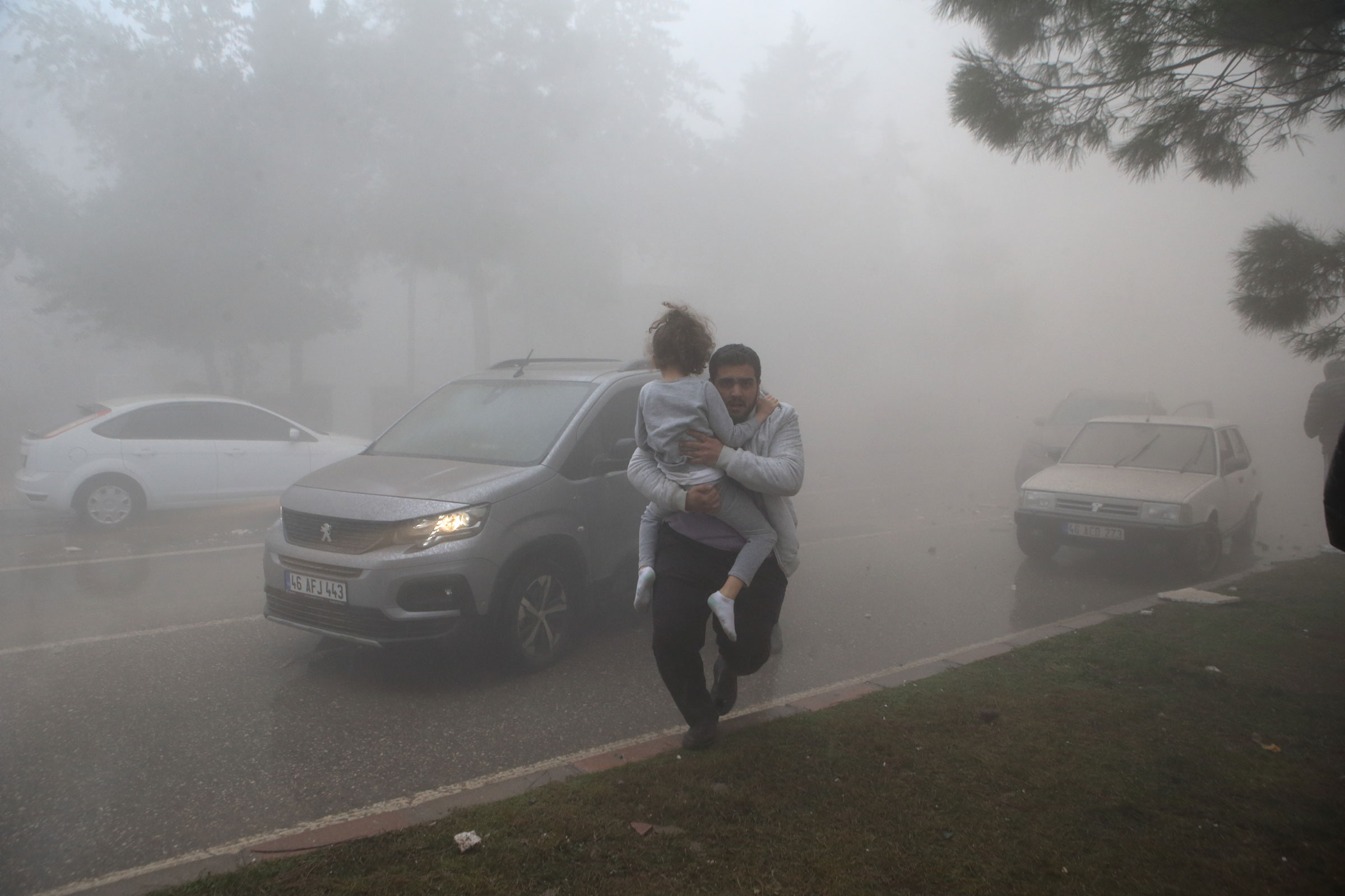 People are seen among the dust cloud formed after a building collapsed in the aftershock in Kahramanmaras. (Kemal Ceylan—Anadolu Agency/Getty Images)