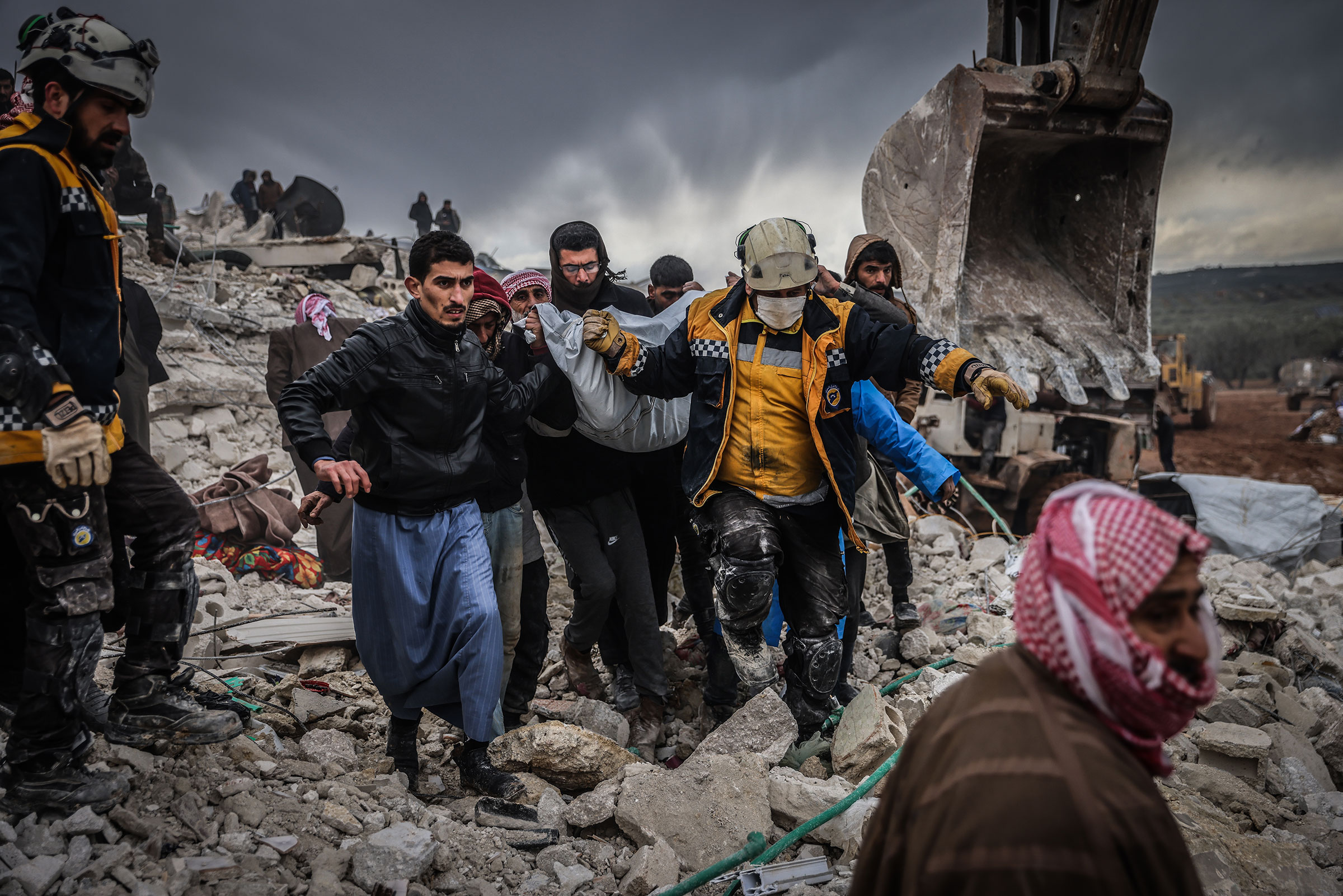 Syrian civilians and members of the White Helmets conduct search and rescue operations in the rubble of a collapsed building in Syria. (Anas Alkharboutli—picture alliance/Getty Images)