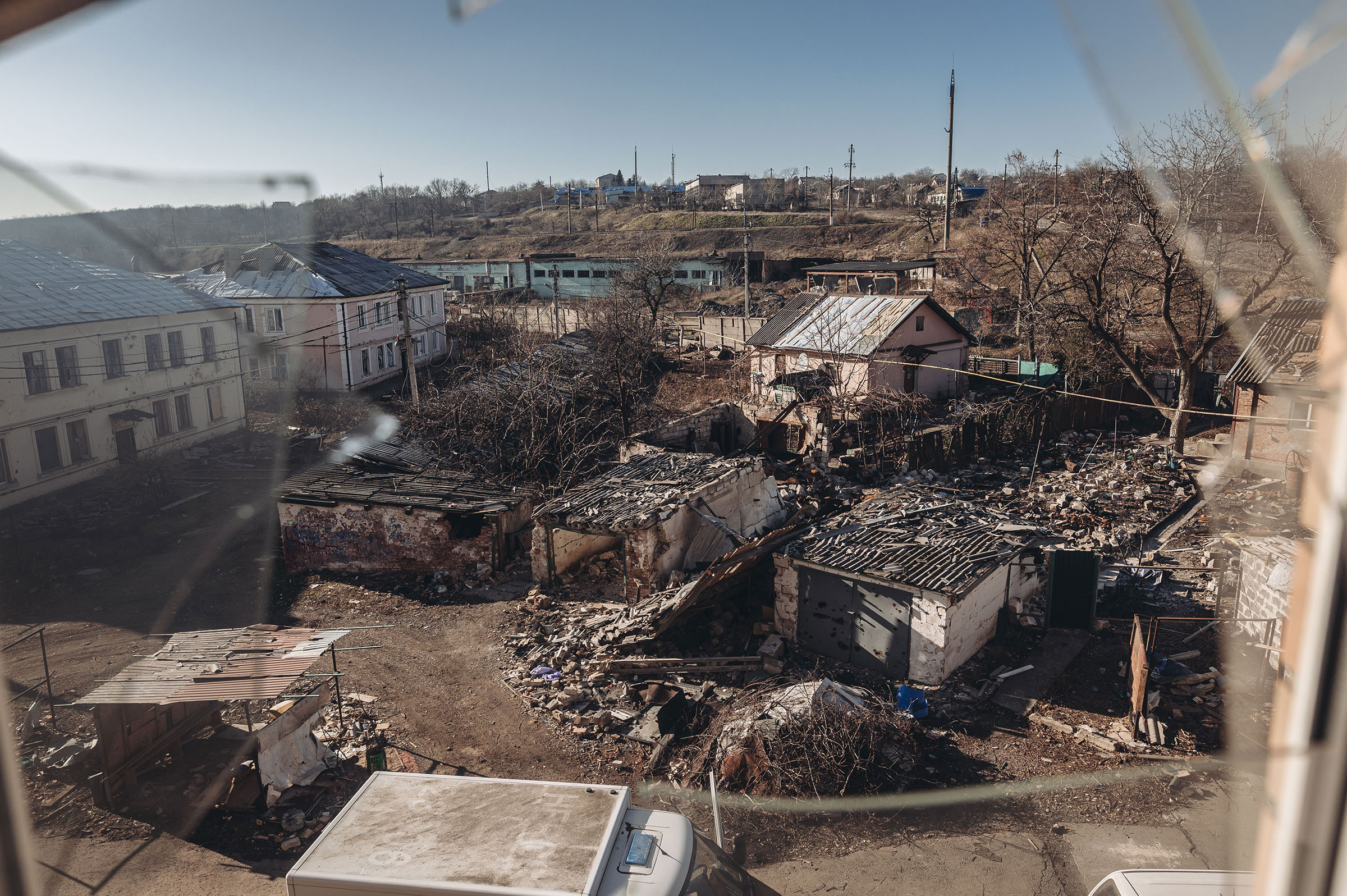 Damaged houses due to Russian shelling are seen through a broken window in Bakhmut, Ukraine, on Jan. 24, 2023 (Diego Herrera Carcedo—Anadolu Agency/Getty Images)