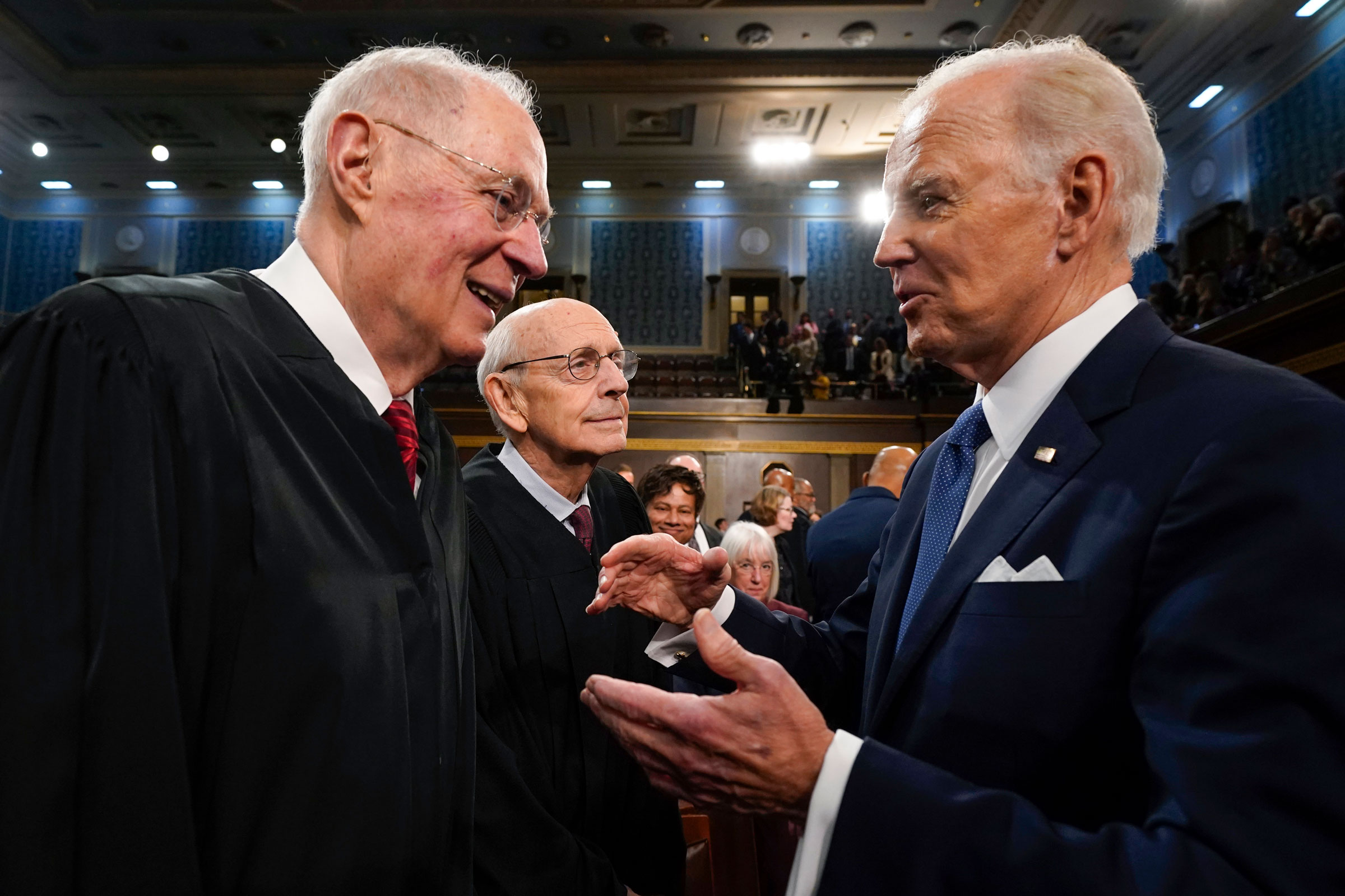 President Joe Biden talks with retired Supreme Court Justice Anthony Kennedy after delivering the State of the Union address