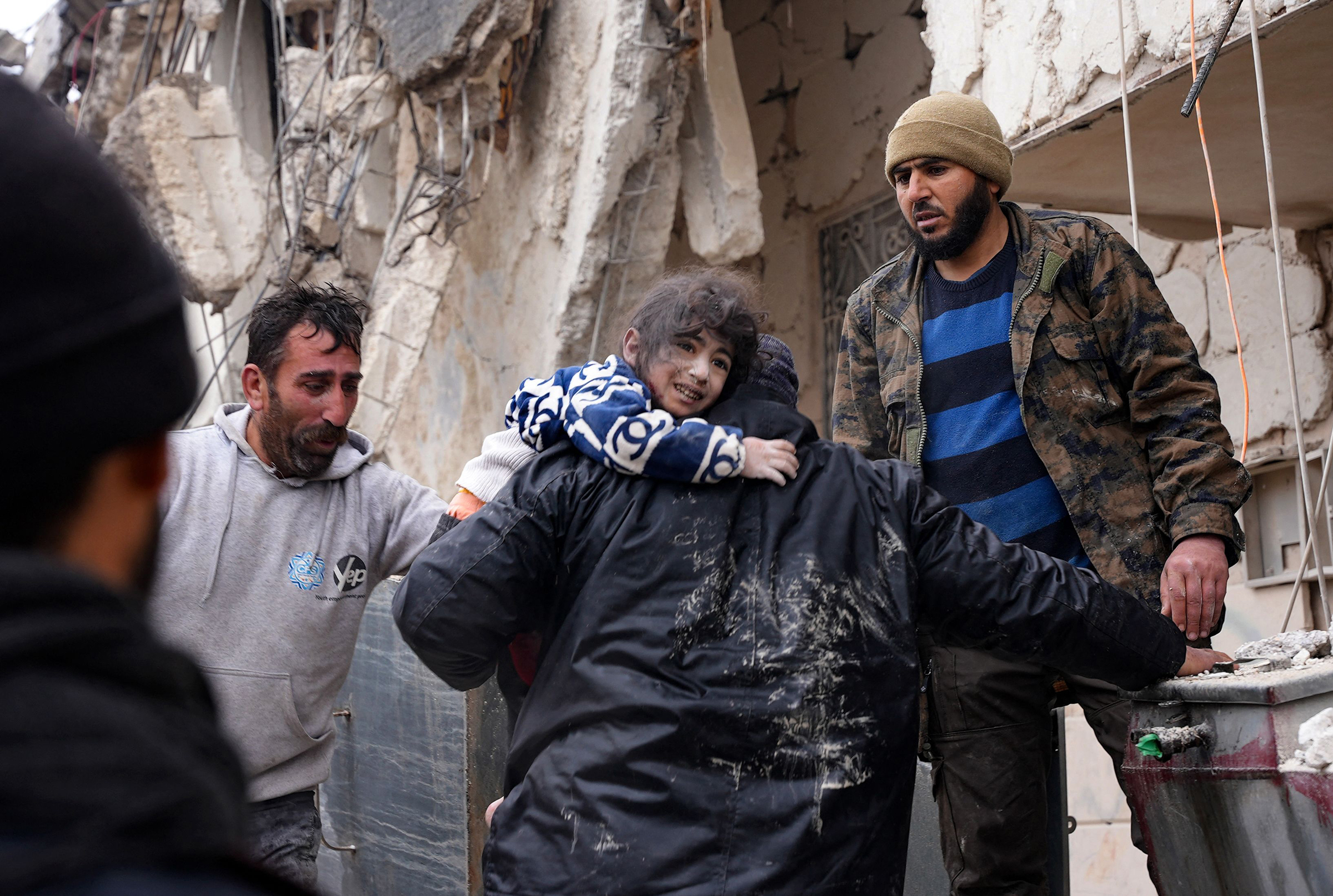 Suriye'nin Jandaris kasabasında meydana gelen depremin ardından mahalle sakinleri çöken bir binanın enkazından bir çocuğu kurtardı.  (Rami Al Sayed—AFP/Getty Images)