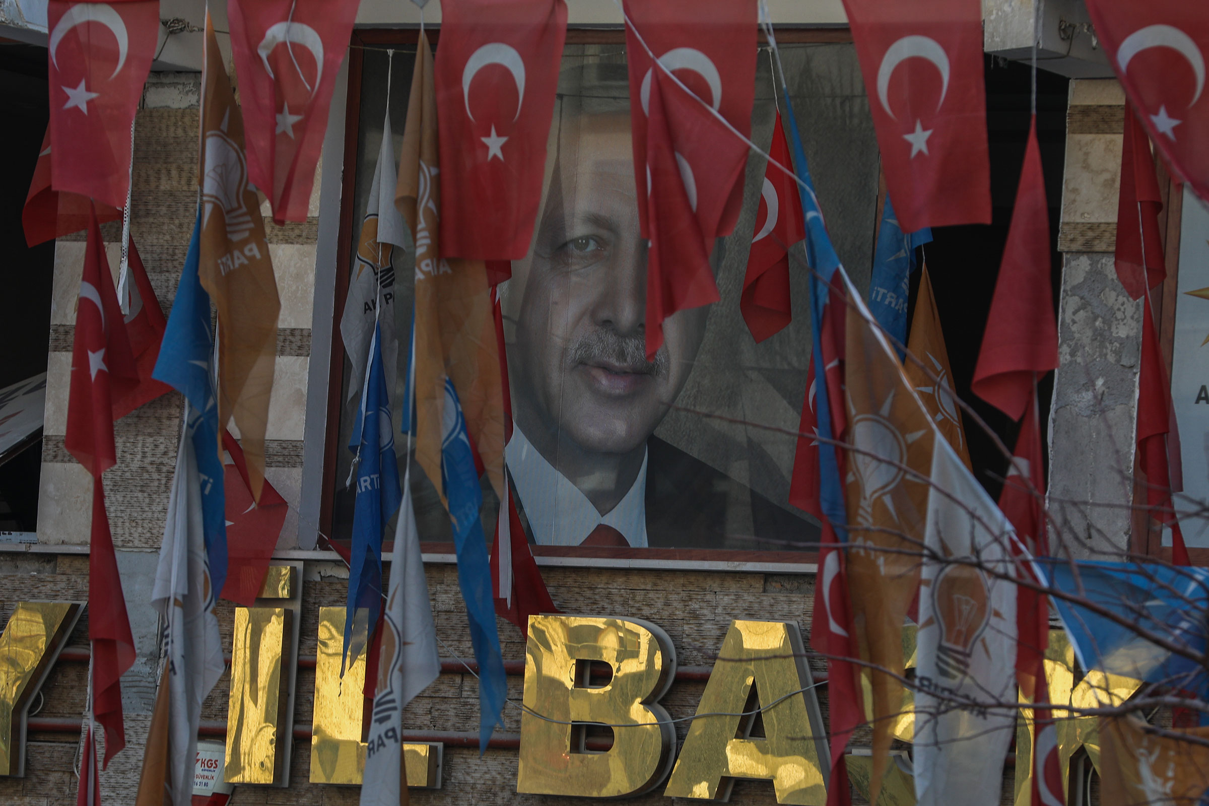 Chân dung của Tổng thống Thổ Nhĩ Kỳ Recep Tayyip Erdogan trước tòa nhà bị hư hại ở Hatay, Thổ Nhĩ Kỳ, vào ngày 13 tháng 2 năm 2023. (Aziz Karimov—Getty Images)