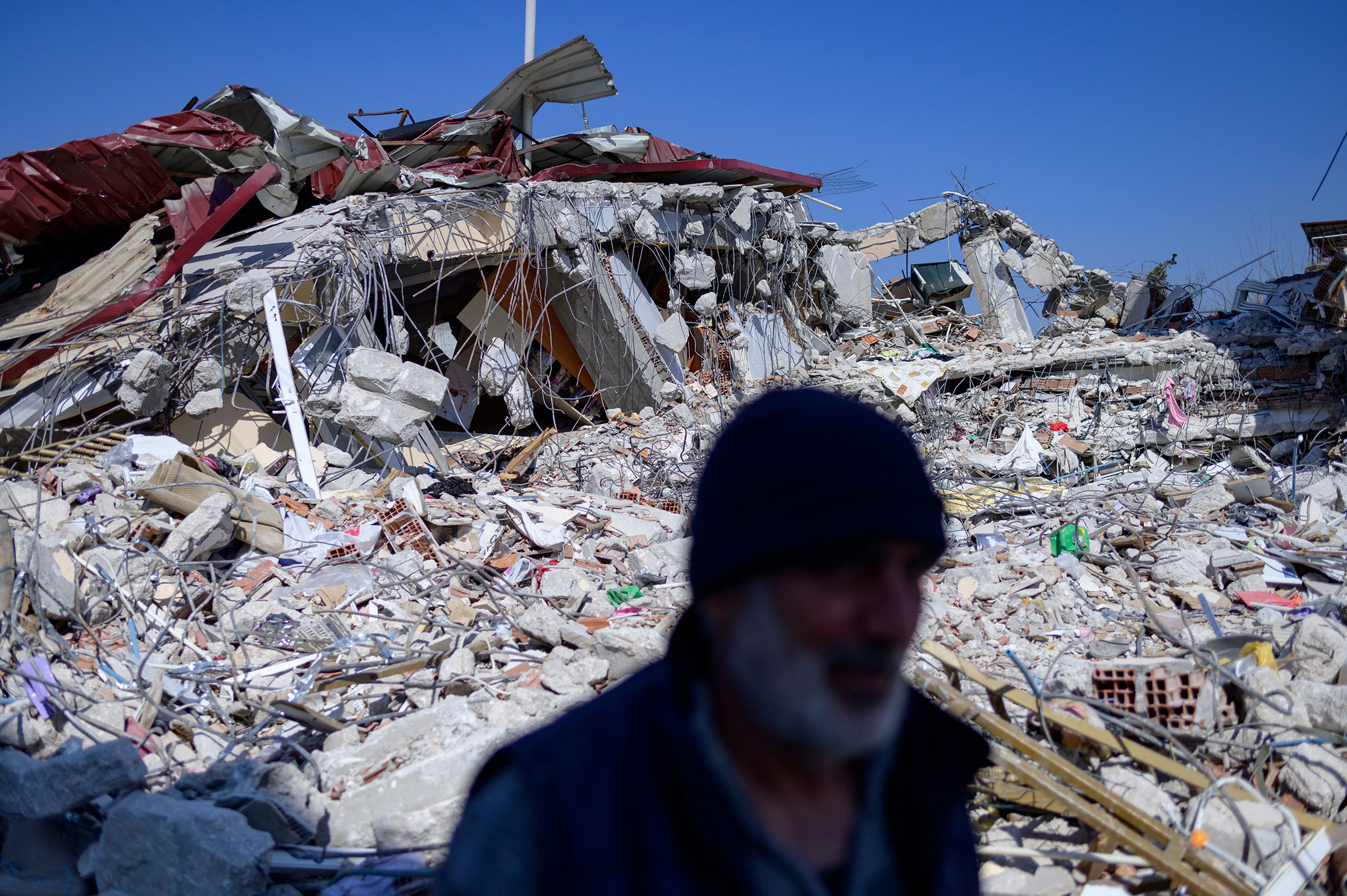 A resident stands in front of his destroyed home in Samandag, south of Hatay on Feb. 16, 2023, ten days after a 7.8-magnitude struck the border region of Turkey and Syria. (Yasin Akgul—AFP/Getty Images)
