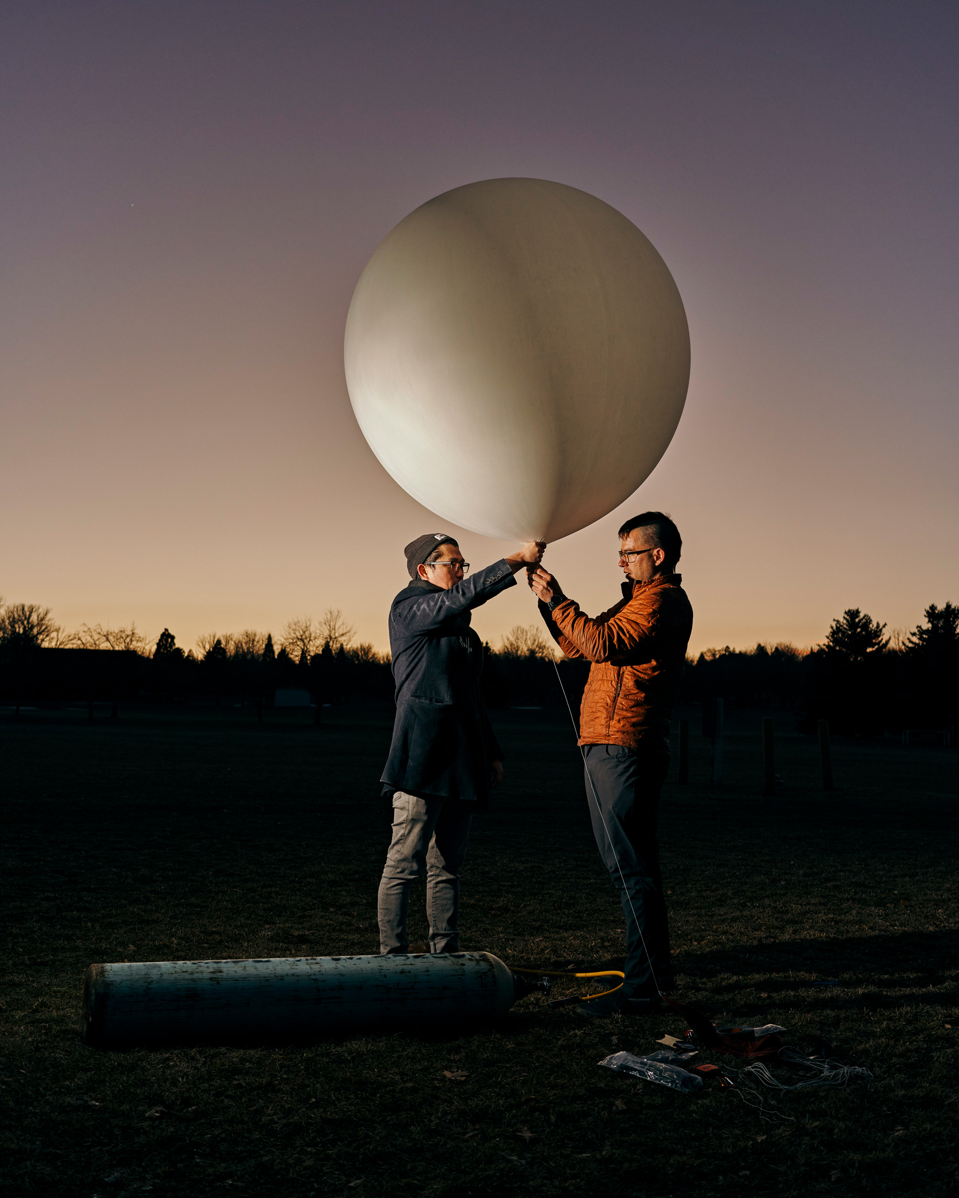 Founder Luke Iseman and co-founder Andrew Song of solar geoengineering startup Make Sunsets hold a weather balloon filled with helium, air and sulfur dioxide at a park in Reno, Nevada, United States on February 12, 2023.