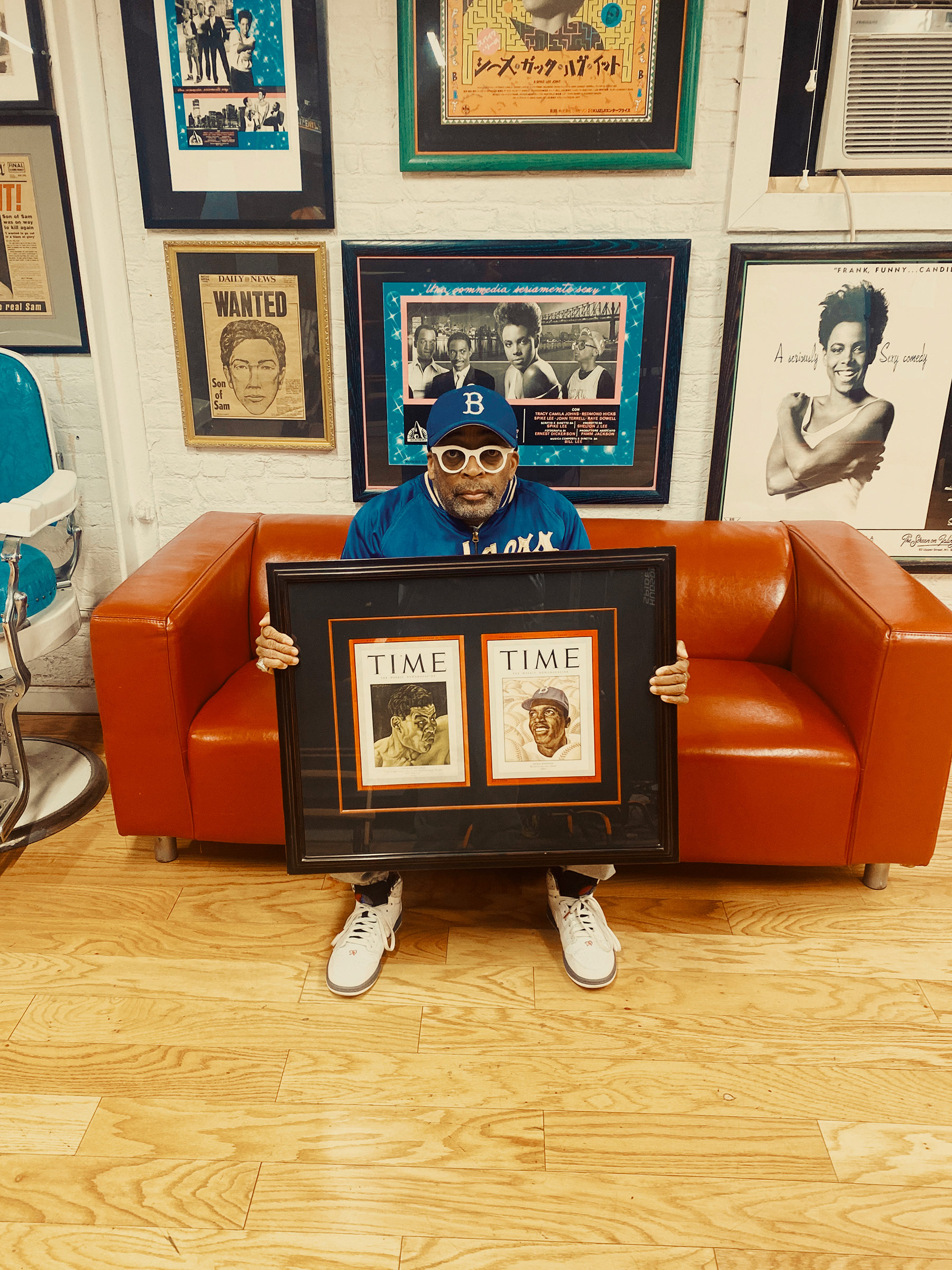 Lee in February with a game-worn Robinson jacket and two TIME covers—Robinson on the right—he displays at his Brooklyn office (Braylen Dion for TIME)