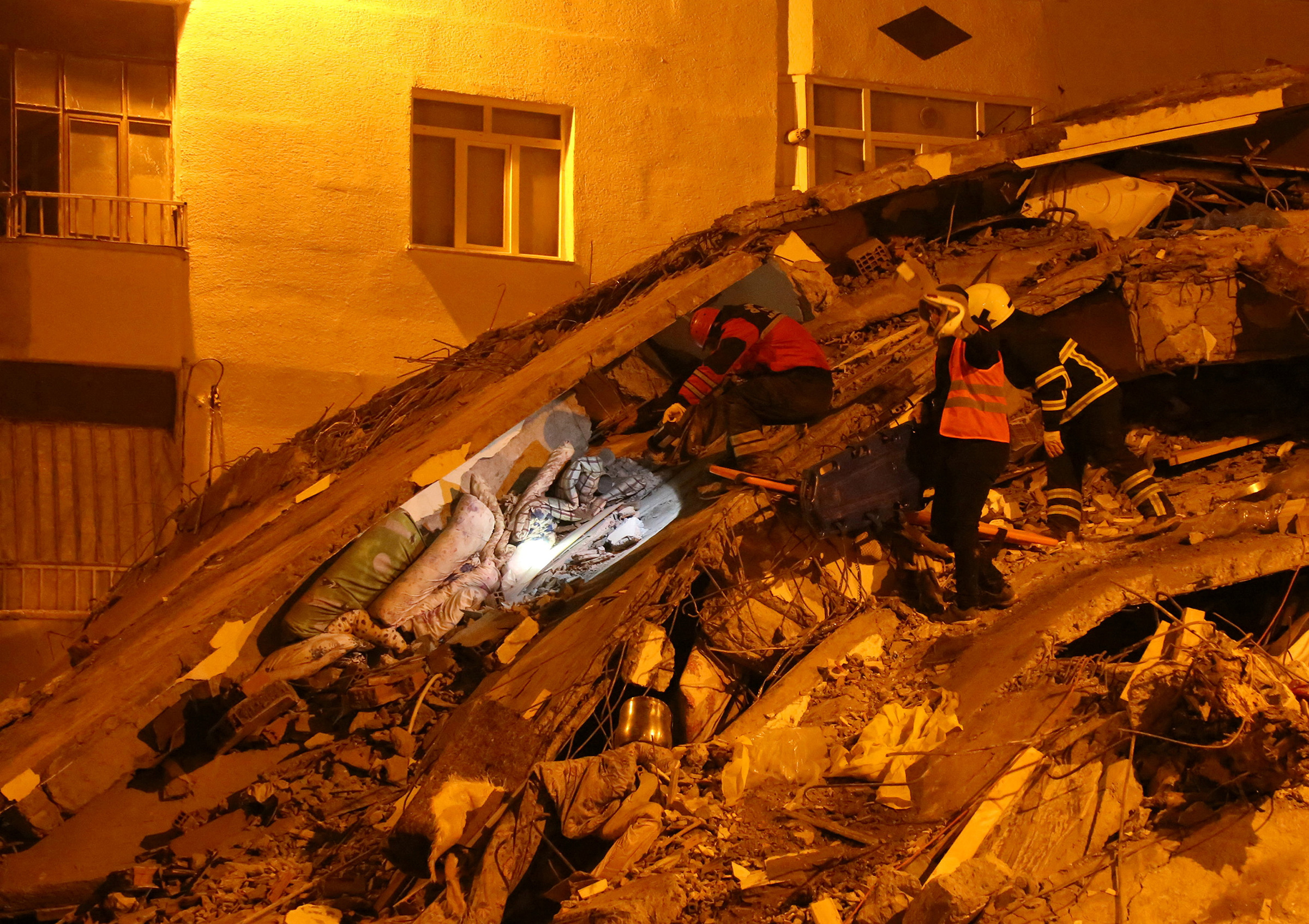 Rescuers search for survivors at the site of a collapsed building following an earthquake in Diyarbakir, Turkey, on Feb. 7. (Sertac Kayar—Reuters)