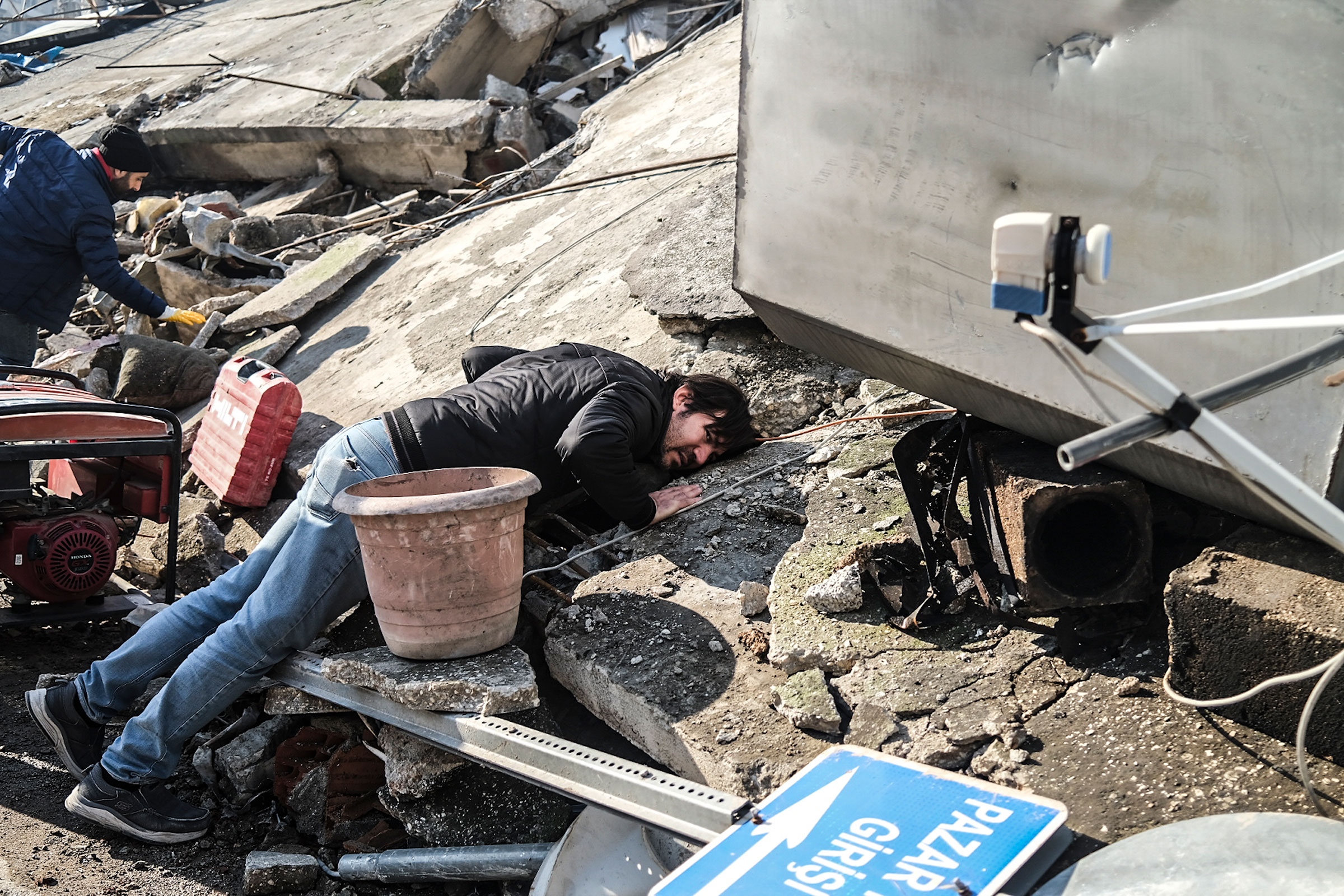A man puts his ear to the rubble searching for the noise of any trapped person. People ask for more help in the Antakya district of Hatay, one of the cities where the biggest debris was experienced. (Murat Kocabas—SOPA Images/LightRocket/Getty Images)
