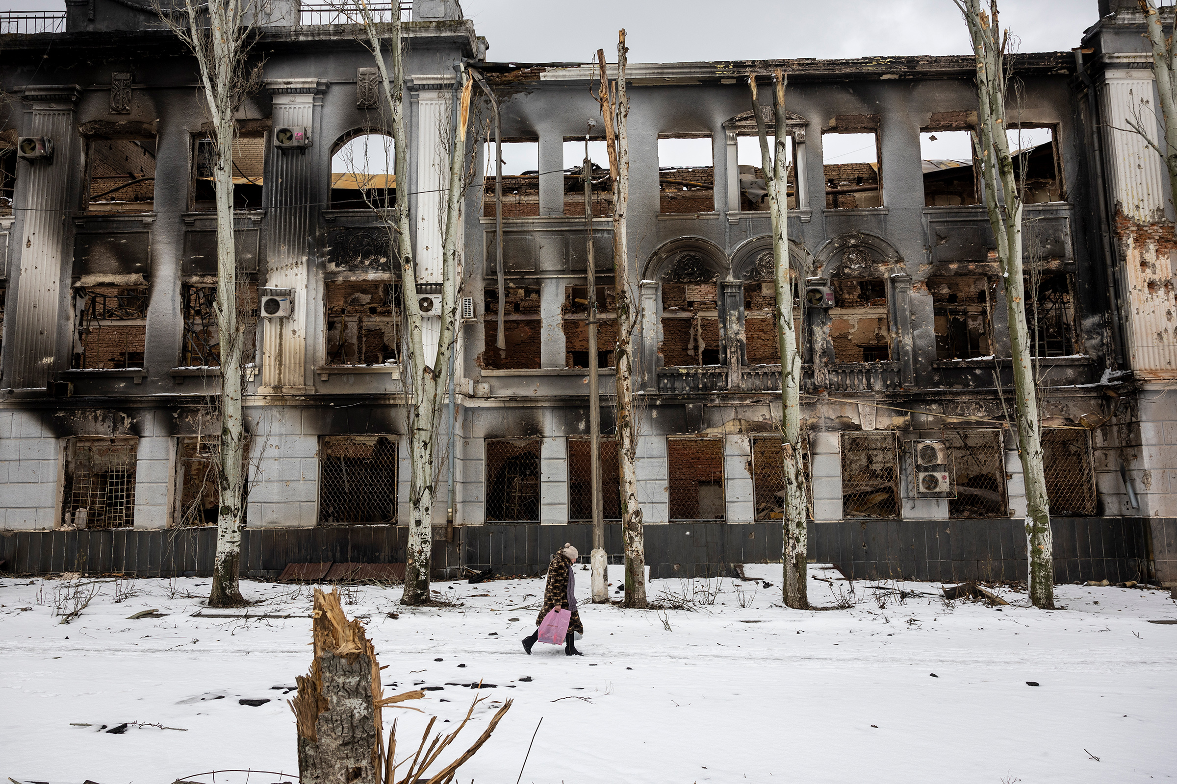 A local resident carries humanitarian aid while walking through a nearly deserted downtown area on Feb. 14 in Bakhmut, Ukraine. (John Moore—Getty Images)