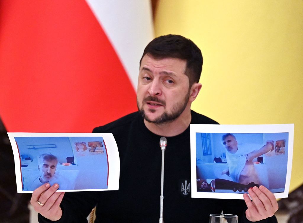 Ukrainian President Volodymyr Zelensky holds images of former Georgian President Mikheil Saakashvili during a joint press conference with his Austrian counterpart following their talks in Kyiv on February 1, 2023. (Sergei Supinsky—AFP/Getty Images)