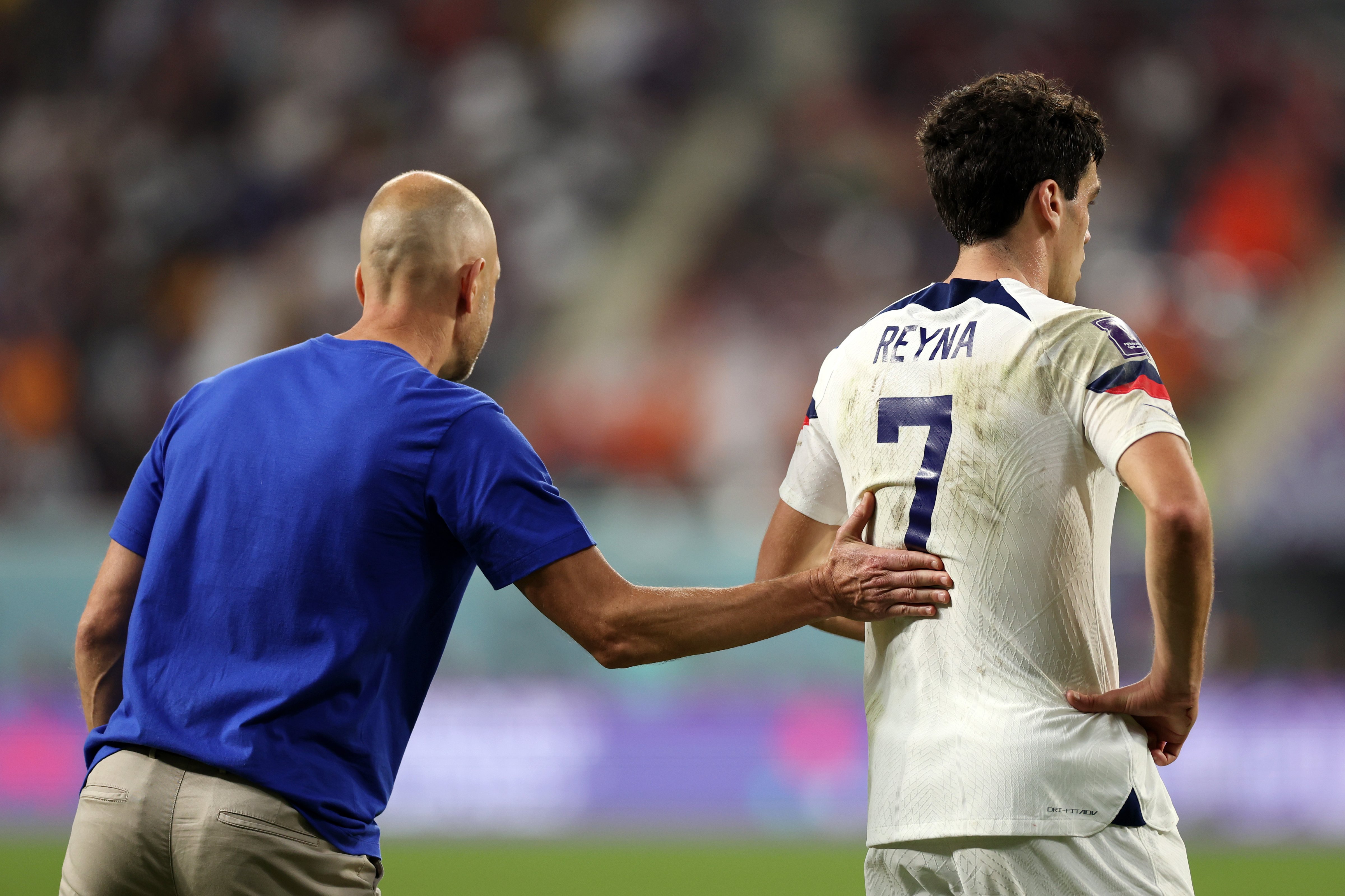 U.S. head coach Gregg Berhalter pats Giovanni Reyna on the back during a match against the Netherlands during the FIFA World Cup in Qatar on Dec. 03, 2022. (Patrick Smith—FIFA/Getty Images)