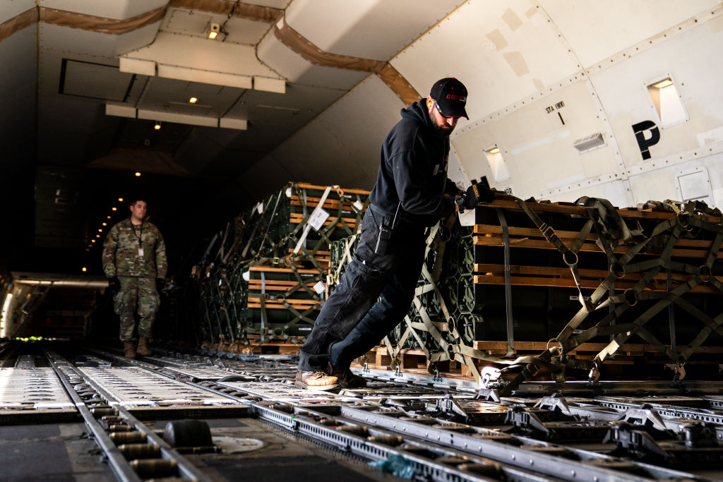 Airman and workers lock pallets of ammunition, weapons and other equipment bound for Ukraine in place on a commercial airline at Dover Air Force Base in Dover, Delaware on Wednesday, October 12, 2022. (Demetrius Freeman—The Washington Post/Getty Images)