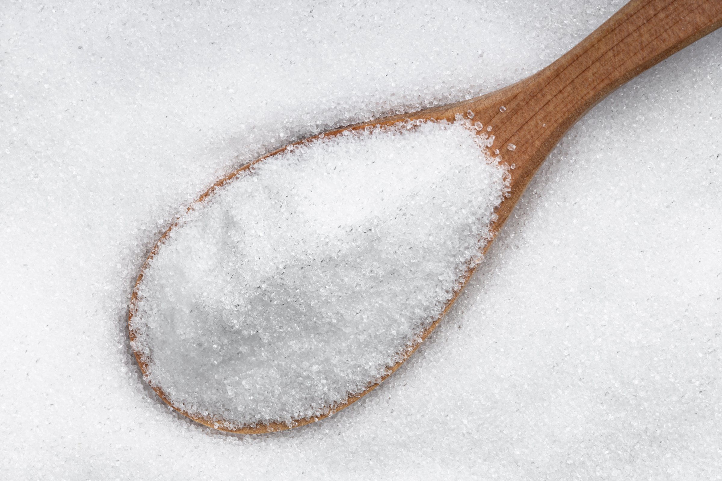 top view of wood spoon with crystalline erythritol