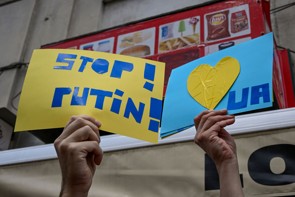 Demonstrators hoist anti Putin signs as Ukrainians and Portuguese nationals protest near the Russian Embassy during a demonstration on Feb. 27, 2022, in Lisbon, Portugal. (Horacio Villalobos—Corbis via Getty Images)