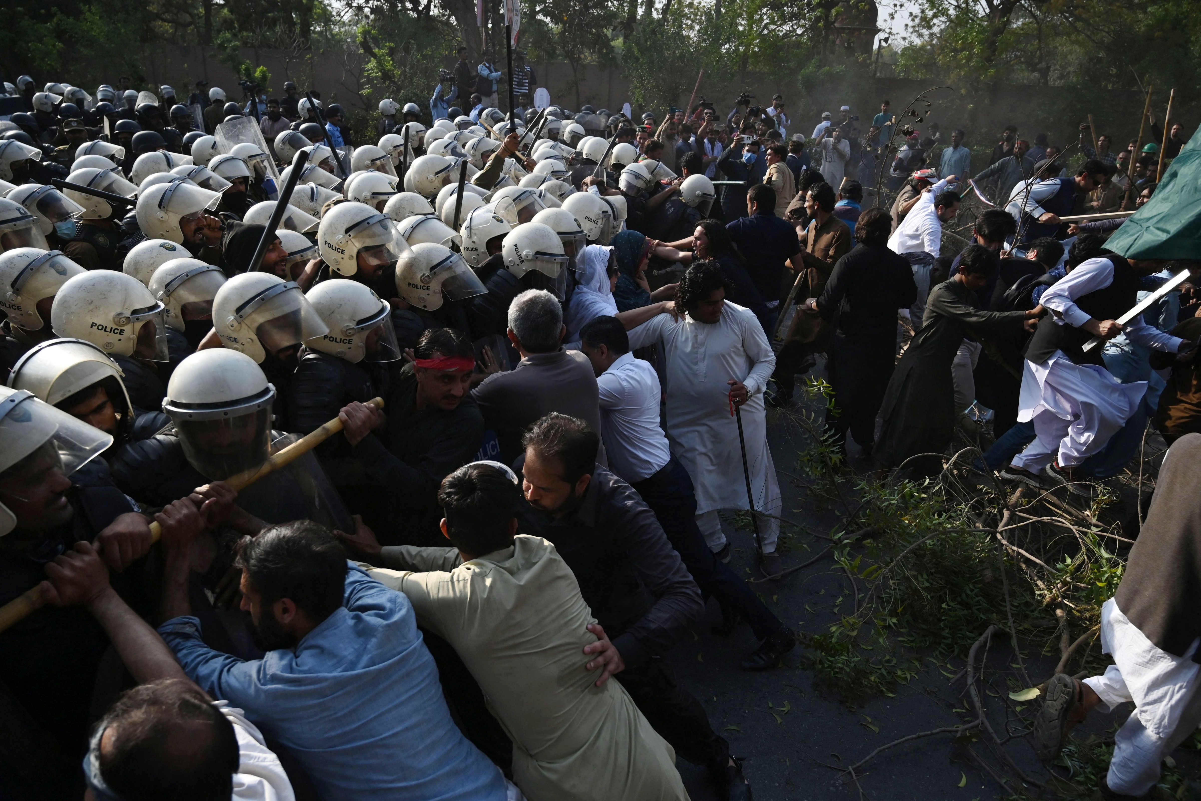 Riot police try to push back supporters of former prime minister Imran Khan gathered outside Khan's house to prevent officers from arresting him, in Lahore, Pakistan, March 14, 2023. (Arif Ali—AFP/Getty Images)