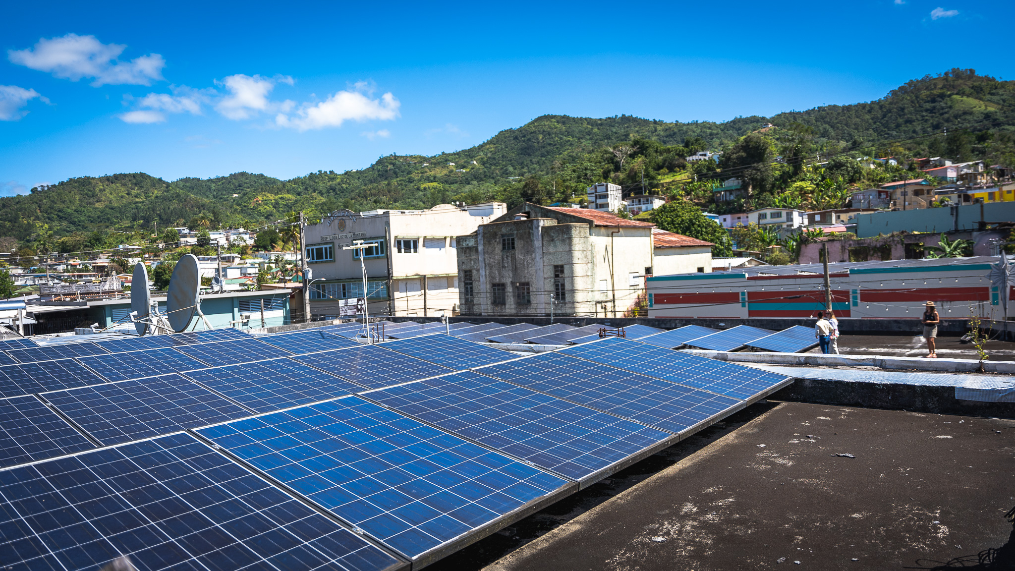 Solar panels on a rooftop in Adjuntas, Puerto Rico, contribute to a new community-owned microgrid project. (Peter Walle, Honnold Foundation)