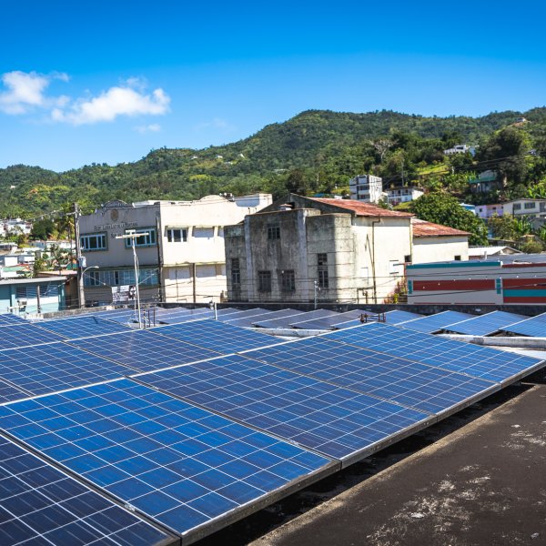 Solar panels on a rooftop in Adjuntas, Puerto Rico, contribute to a new community-owned microgrid project.