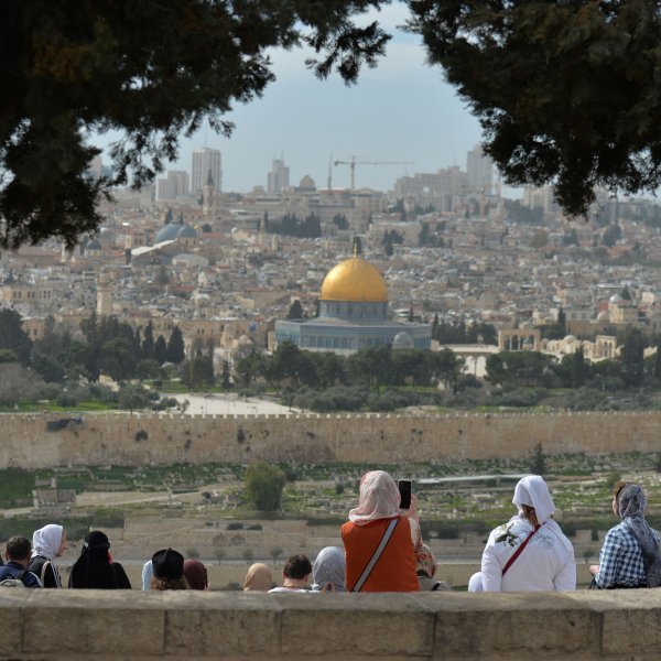 Tourists look from the Mount of Olives at the Old City of Jerusalem.