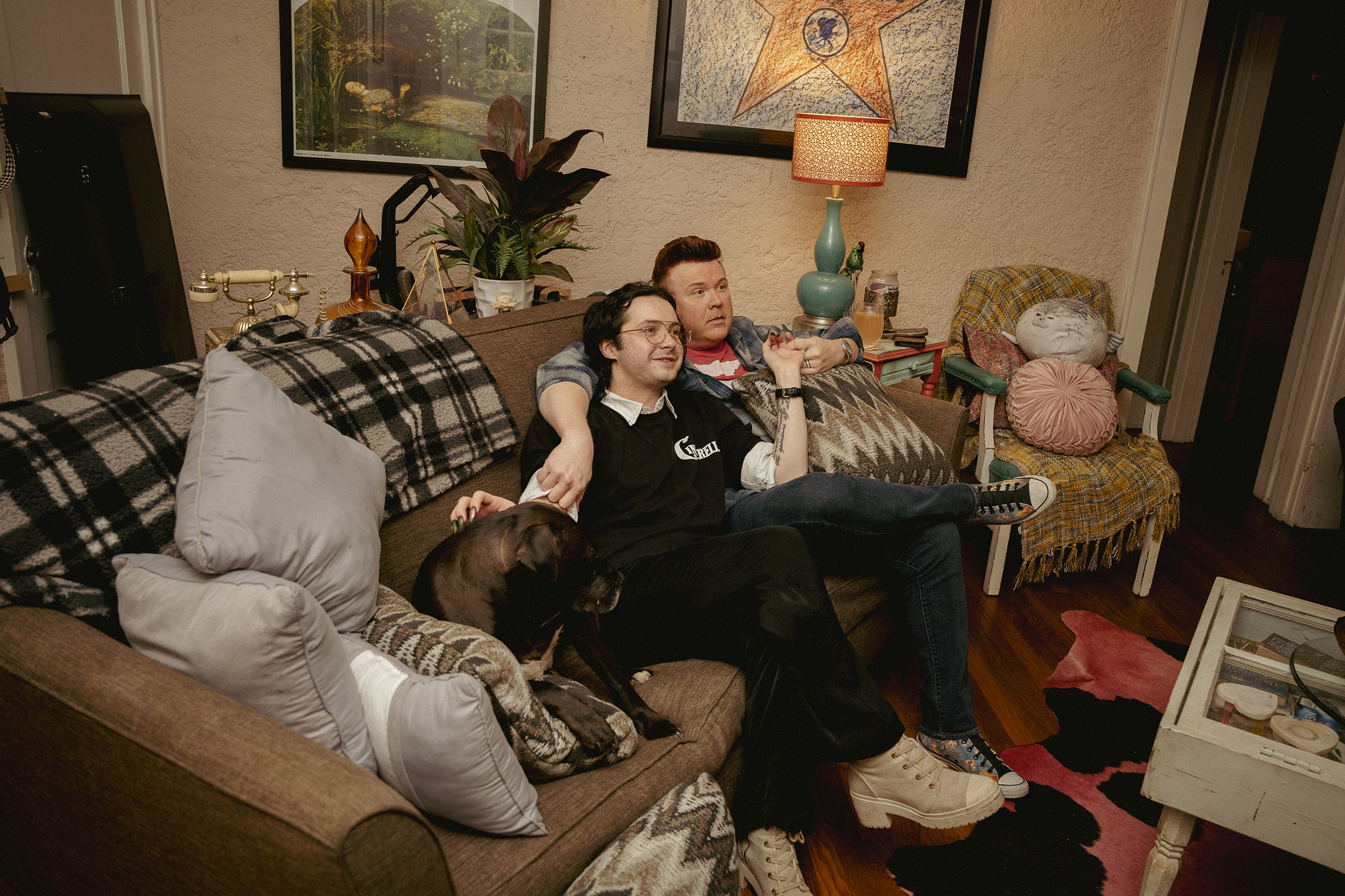 Kelly McDaniel (right) and his husband Austin Wood-McDaniel (left) hang out in their living room after working their day jobs on March 29.