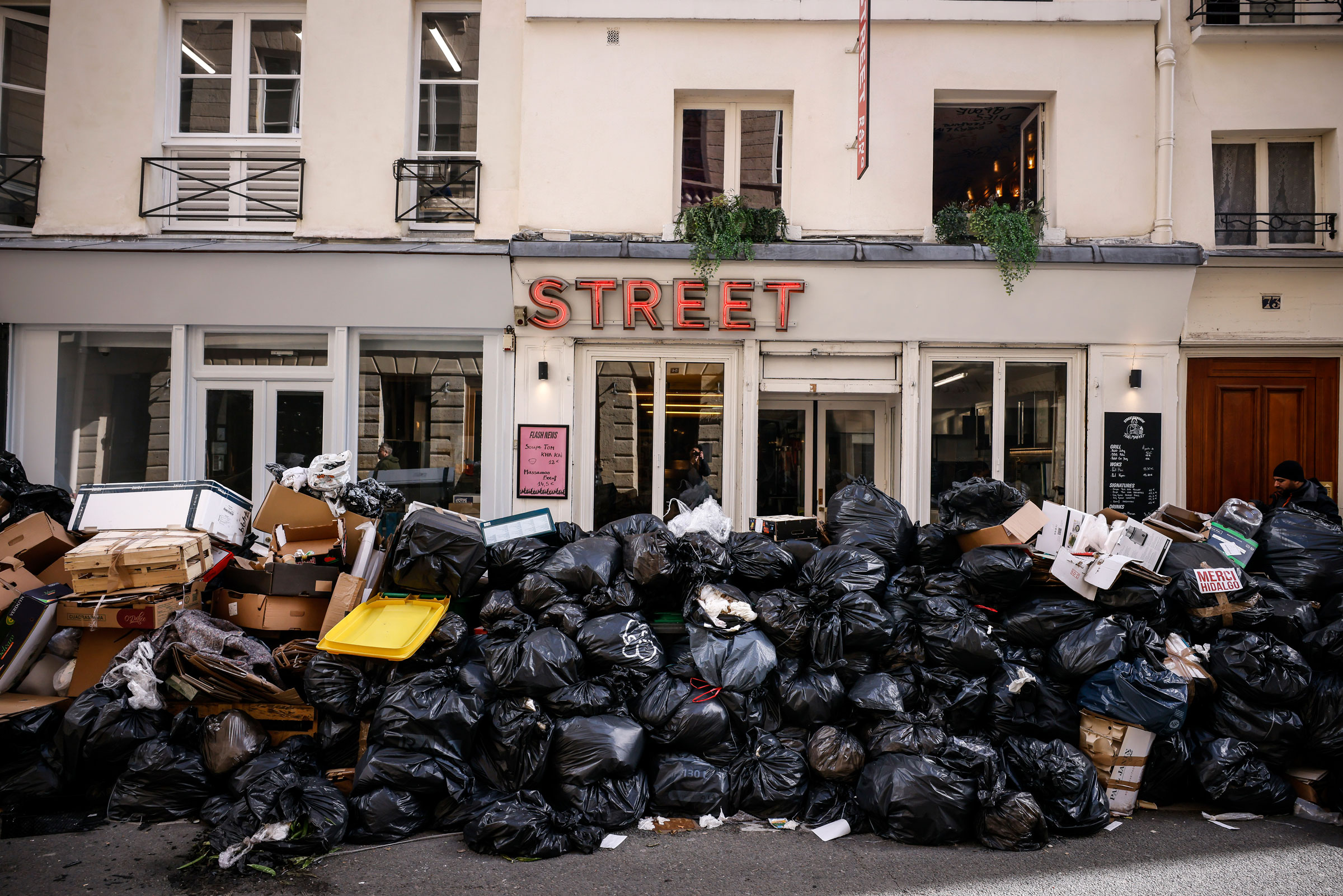 15 Mart 2023'te temizlik işçilerinin devam eden grevi sırasında Paris'te bir caddede toplanmayan çöpler yığılıyor. (Thomas Padilla—AP)