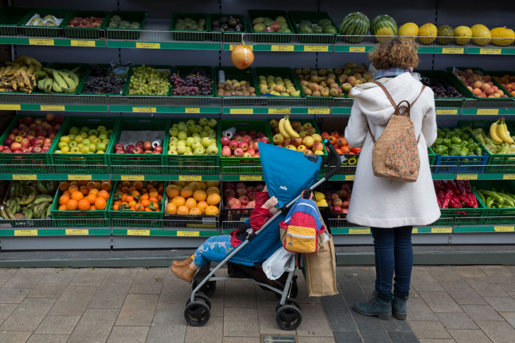 A mother and child stop to choose fruit and vegetables from the shelves of oranges, bananas, apples, and grapes, in February 2020, in London, England. (Richard Baker / In Pictures—Getty Images)