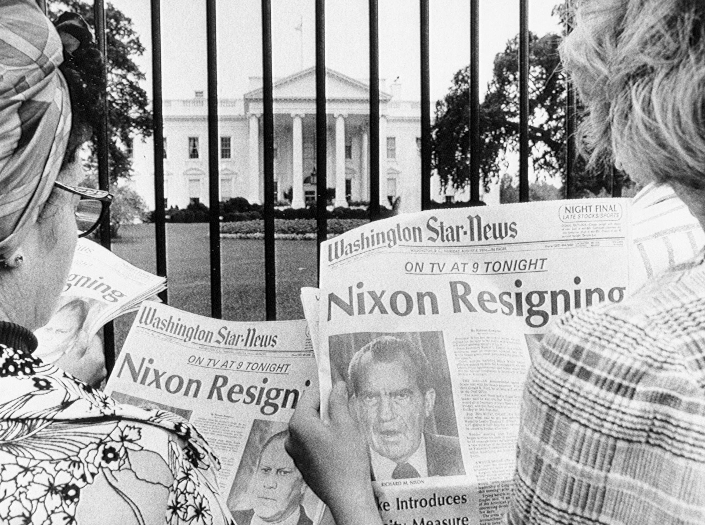 Newspaper headlines being read by tourists in front of the White House on Aug. 8, 1974. (Bettmann Archive/Getty Images)