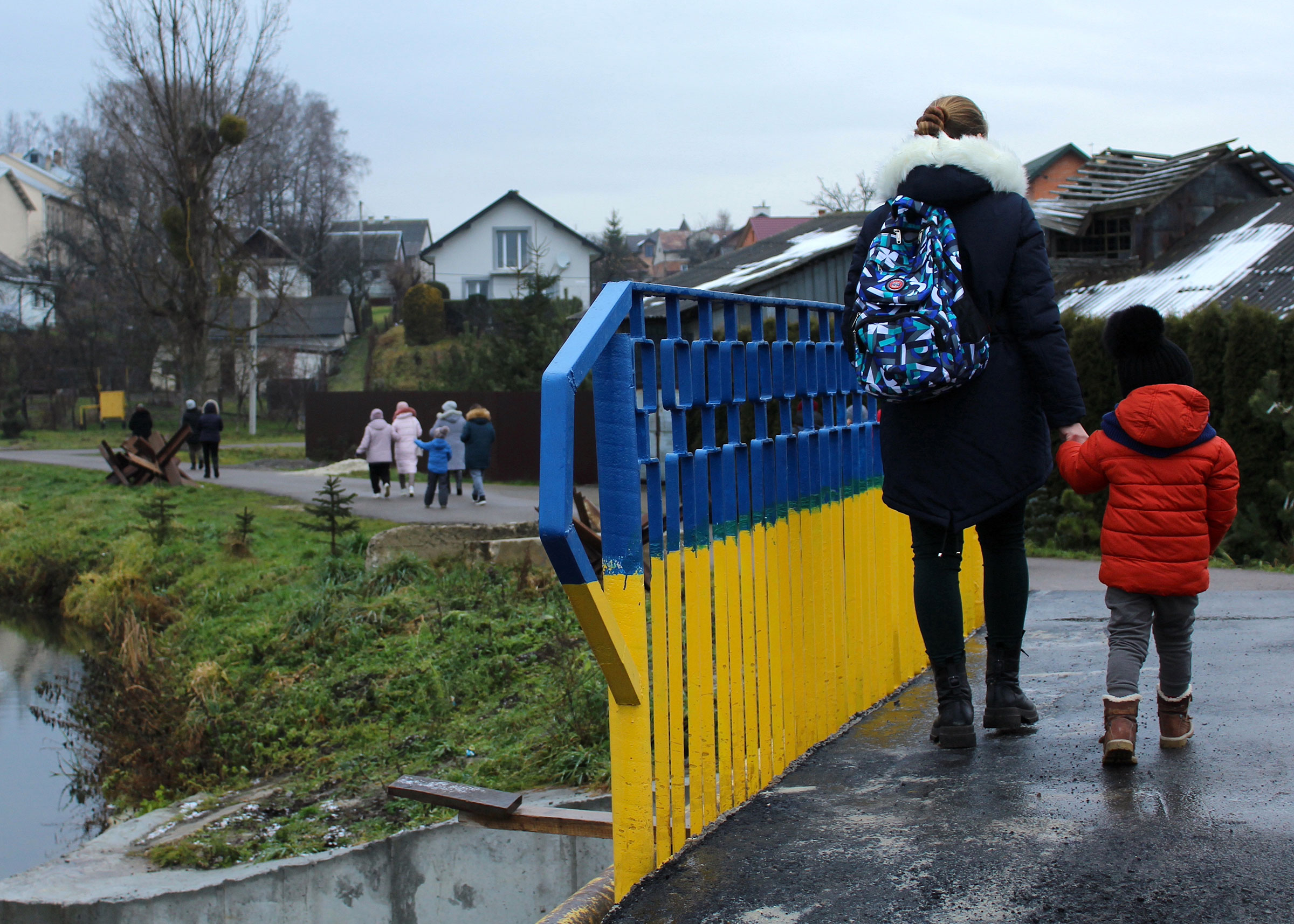 A domestic violence survivor and her child walk across a bridge during an excursion outside of Lviv, organized by the Centre for Women's Perspectives. (Jessie Williams for the Fuller Project)