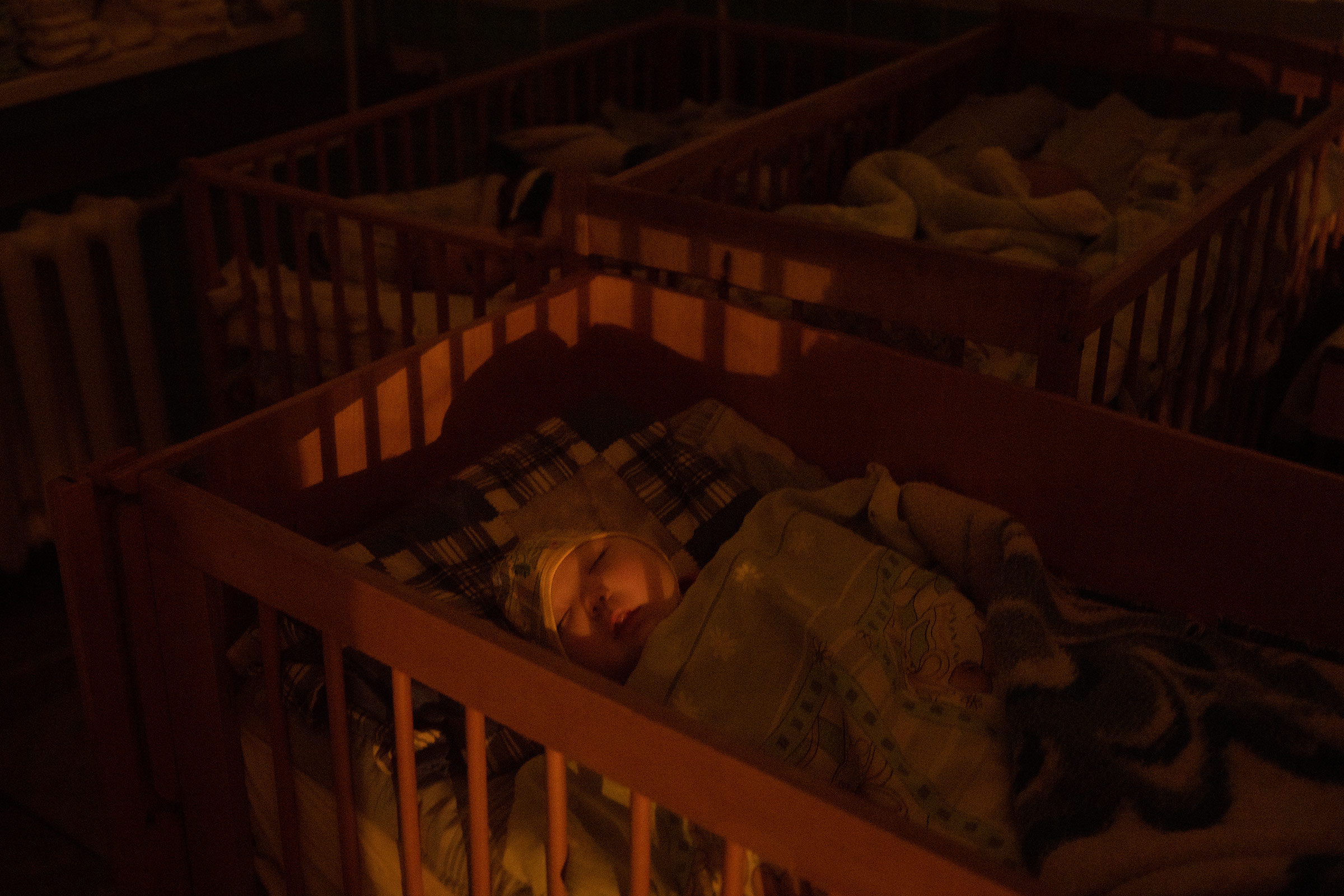 An orphan sleeps in their crib at the Kherson Regional Children’s hospital on Nov. 26, 2022 in Kherson, Ukraine. The hospital staff cared for a group of 10 orphans after hearing about the mass deportation of Ukrainian children to Russia. (Chris McGrath—Getty Images)