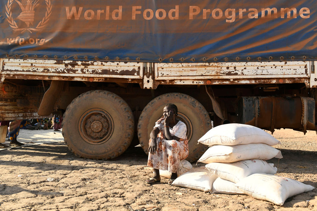 An internally displaced women sits next to a World Food Programme truck during a food distribution in Bentiu on February 6, 2023. (Simon Maina—AFP/Getty Images)