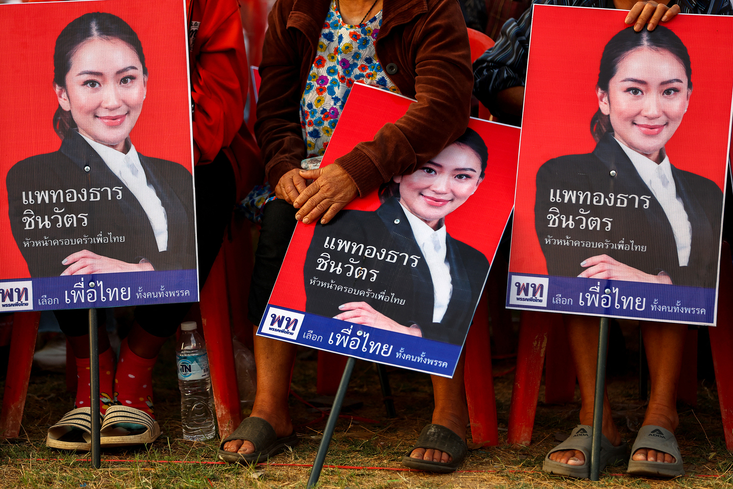 Supporters hold posters of Paetongtarn Shinawatra during the general election campaign in Ubon Ratchathani province, Thailand, on Feb. 17. (Athit Perawongmetha—Reuters)