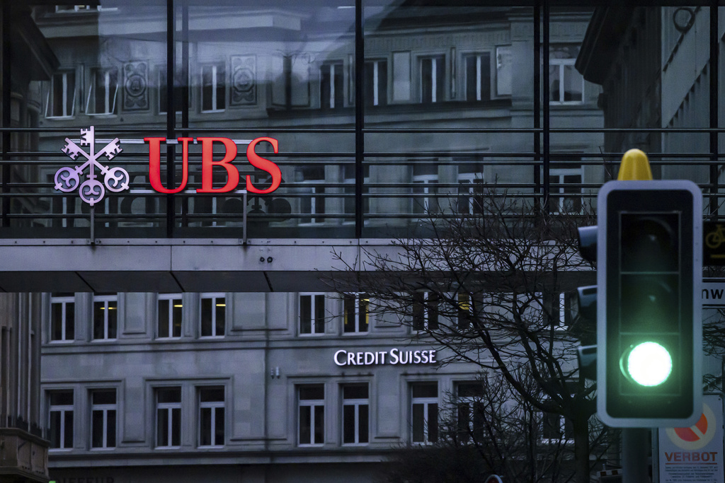A traffic light signals green in front of the logos of the Swiss banks Credit Suisse and UBS in Zurich, Switzerland, on March 19, 2023. (Michael Buholzer—Keystone/AP)