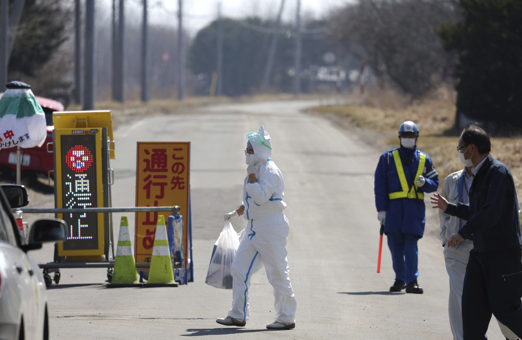 About 120 local government staff and about 90 Japan Ground Self-Defense Force members work to slaughter more than 500,000 egg-laying hens at a poultry farm with an outbreak of the avian influenza in Chitose City, Hokkaido Prefecture, northern Japan, March 28, 2023. (Yomiuri Shimbun/AP Images)