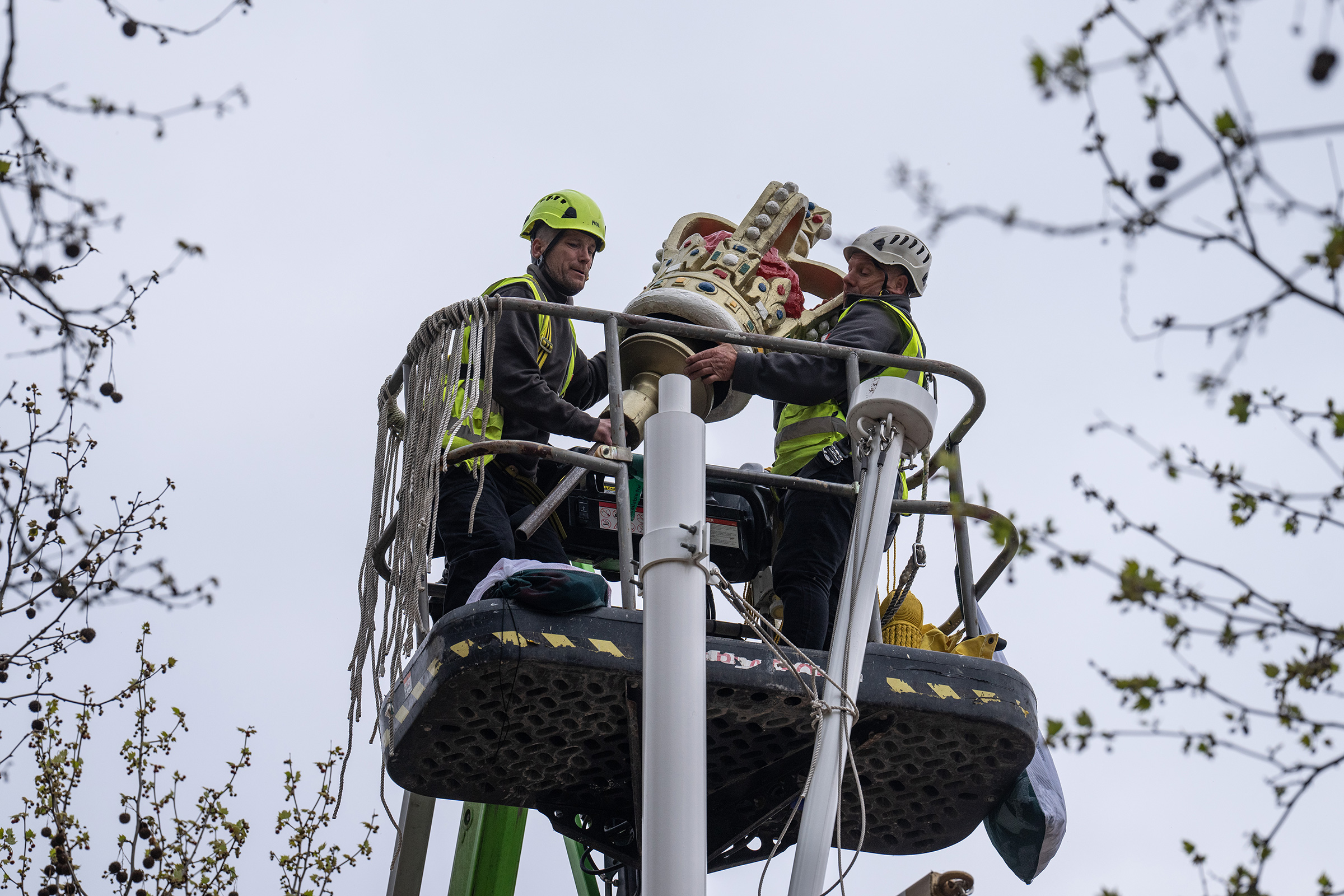 A crown is lifted into place atop a flag pole on The Mall on April 17. (Carl Court—Getty Images)