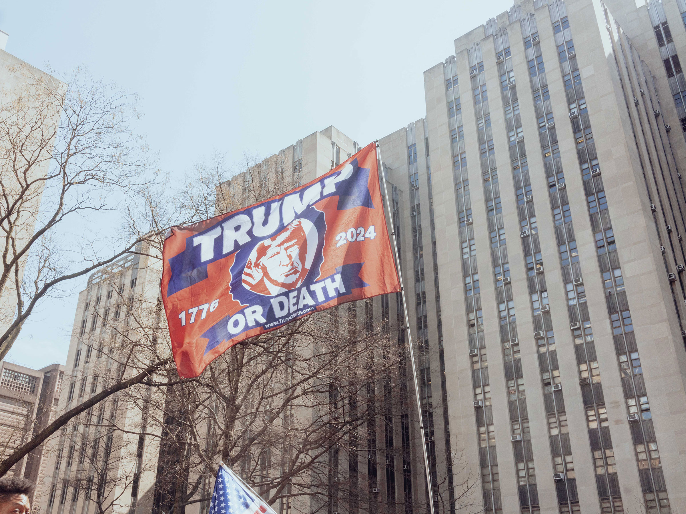 A supporter of former President Donald Trump waves a flag during a rally outside criminal court in New York City on April 4, 2023. (Ismail Ferdous—Bloomberg/Getty Images)