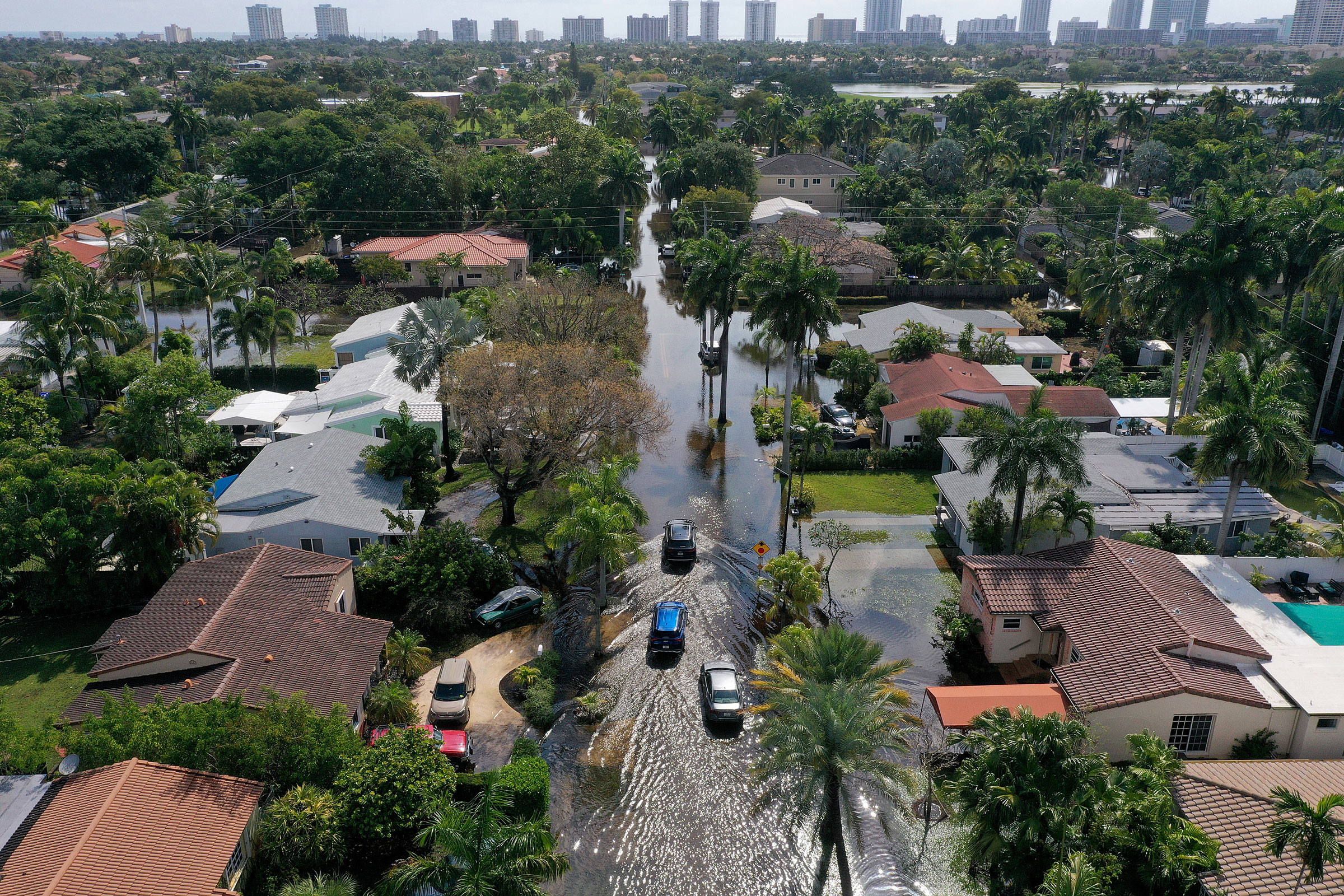 Cars navigate through flooded streets after record rains fell in Hollywood, Fla., on April 13, 2023.