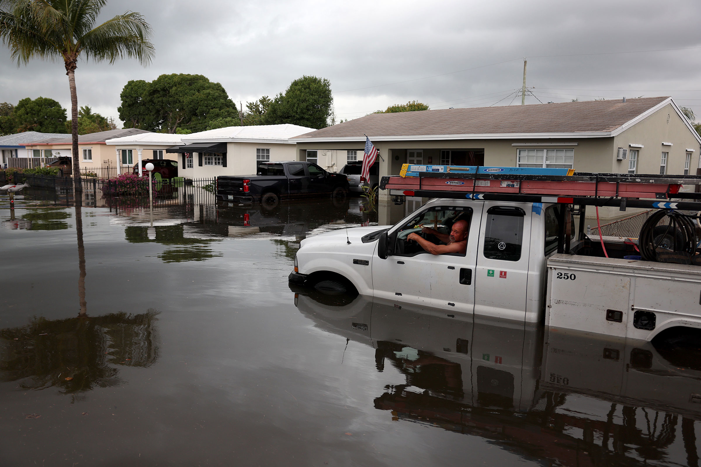 A person sits in a stalled truck along a flooded street in Fort Lauderdale, Fla., on April 13, 2023. (Joe Raedle—Getty Images)