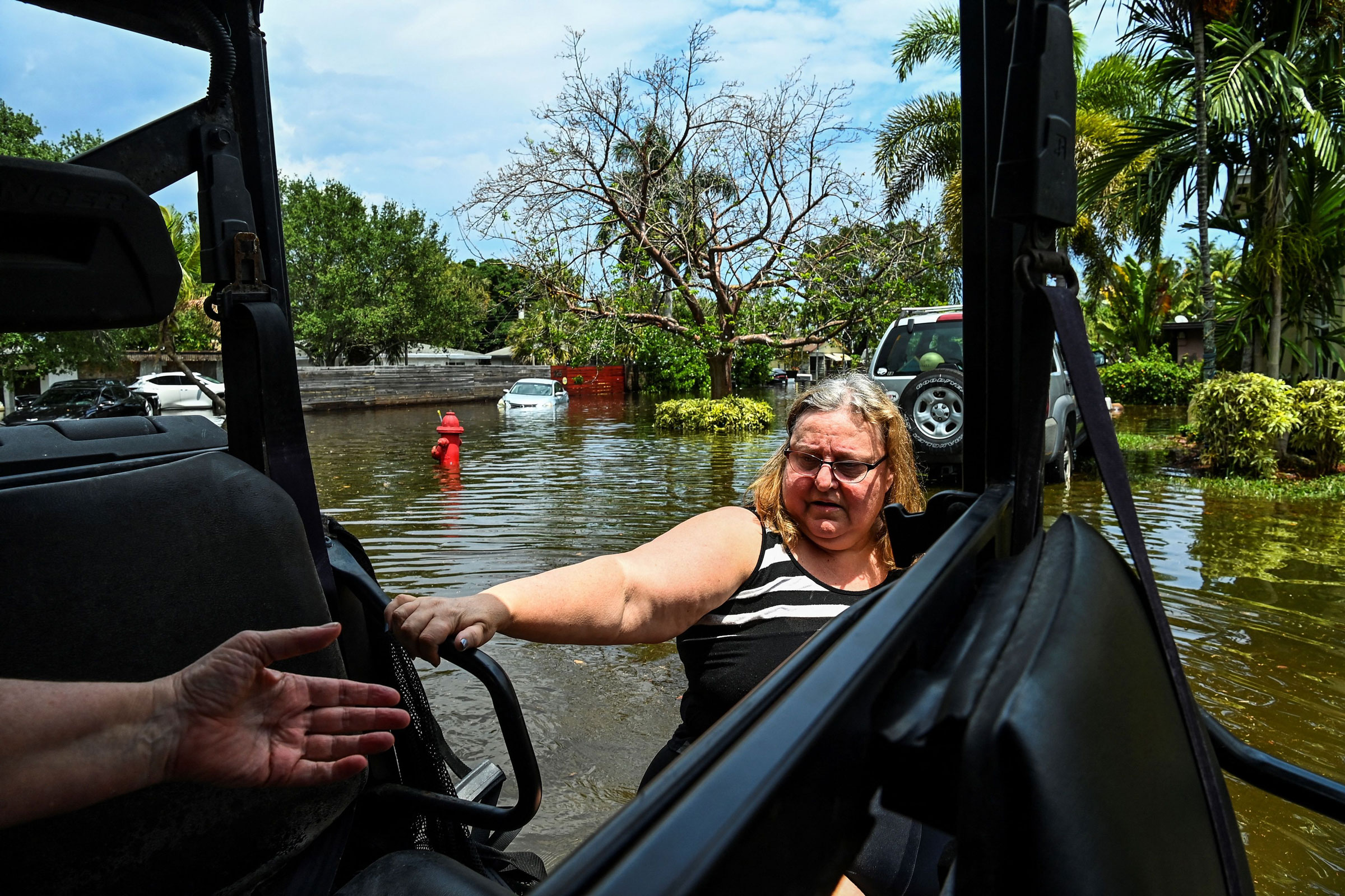 A woman is rescued by Florida Fish and Wildlife Conservation law enforcement, on the flooded street after heavy rain in Fort Lauderdale