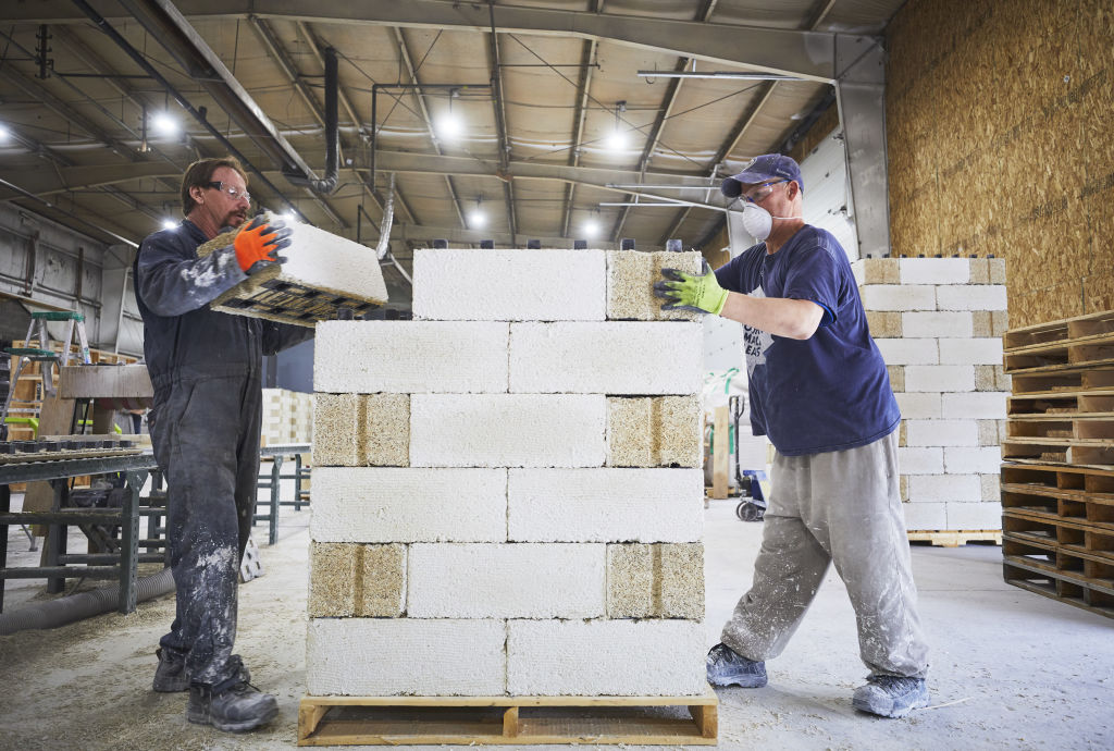 Workers stack hemp bricks at the JustBioFiber Structural Solutions manufacturing facility in Alberta, Canada, on Thursday, Aug. 1, 2019. Hemp, helps builders limit their carbon footprints. (Todd Korol/Bloomberg—Getty Images)