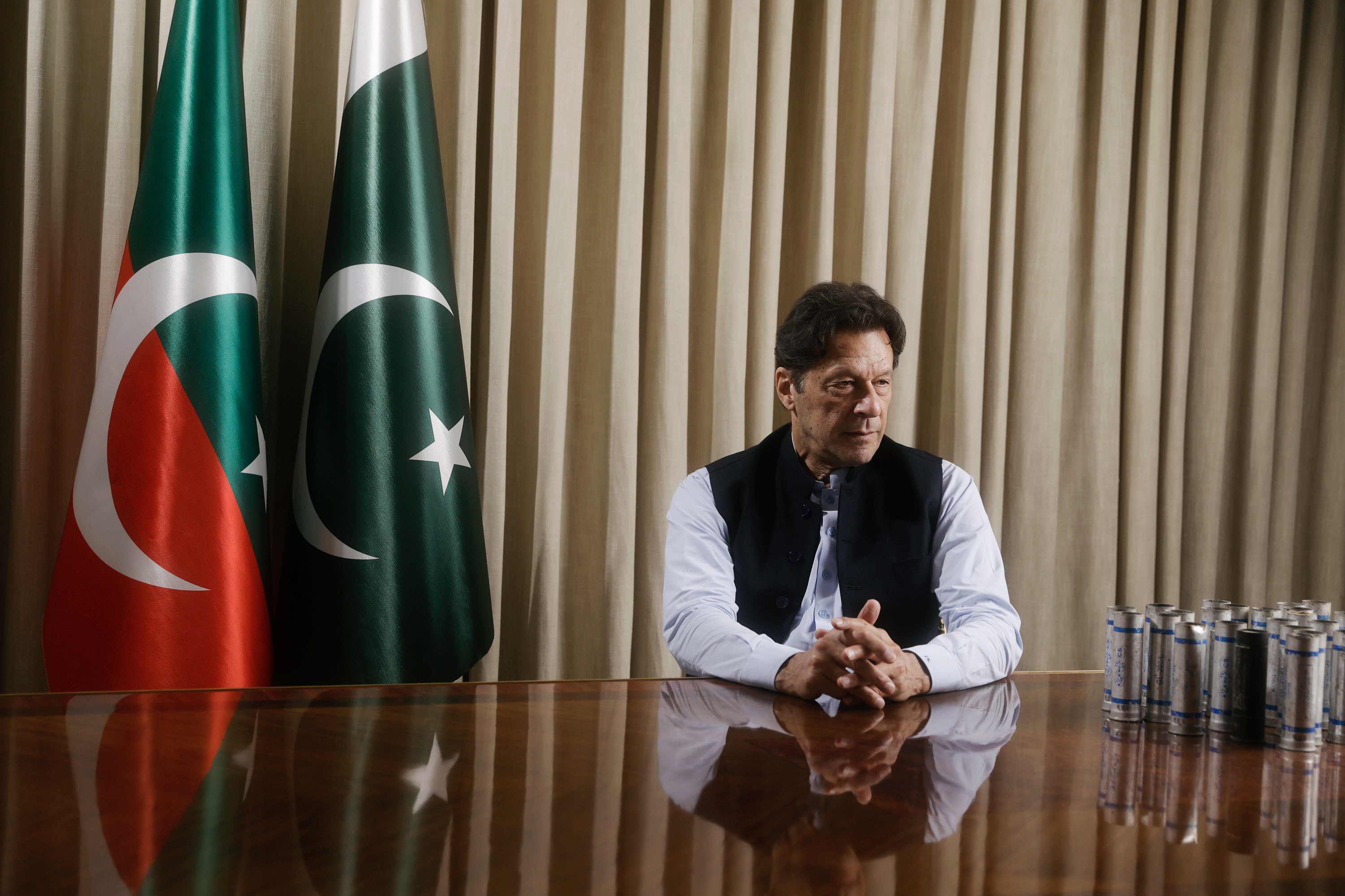 Former Pakistan Prime Minister Imran Khan sits for a portrait in his Lahore residence on March 28. Next to Khan are tear gas canisters he says were thrown at his house. (Umar Nadeem for TIME)