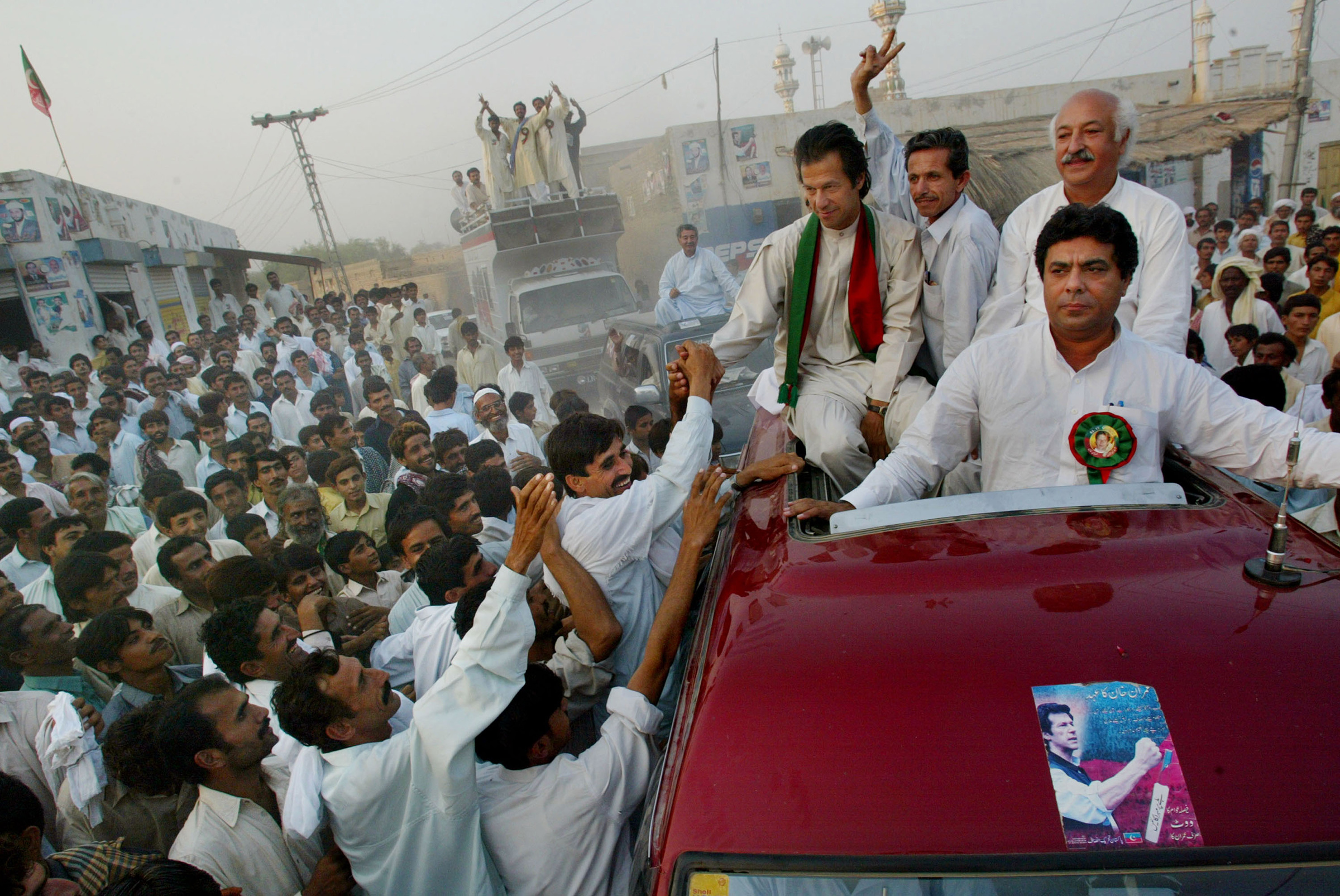 Cricket captain turned politician Imran Khan shakes hands with supporters during a rally in October 2002 in Shadi Khal, Pakistan. (Paula Bronstein—Getty Images)