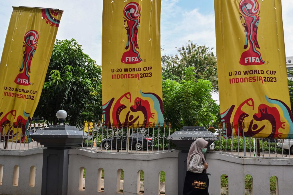 A woman passes banners calling for the Women's Under-20 World Cup after Indonesia canceled the tournament, in Jakarta, March 30, 2023.  (Adec Berry-AFP/Getty Images)