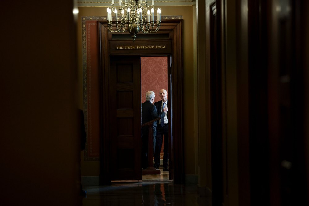 Senate Minority Leader Mitch McConnell speaks with Sen. Rick Scott before a meeting with Republican Senators on their party's plan for the vote on the debt limit at the Capitol on Oct. 07, 2021.