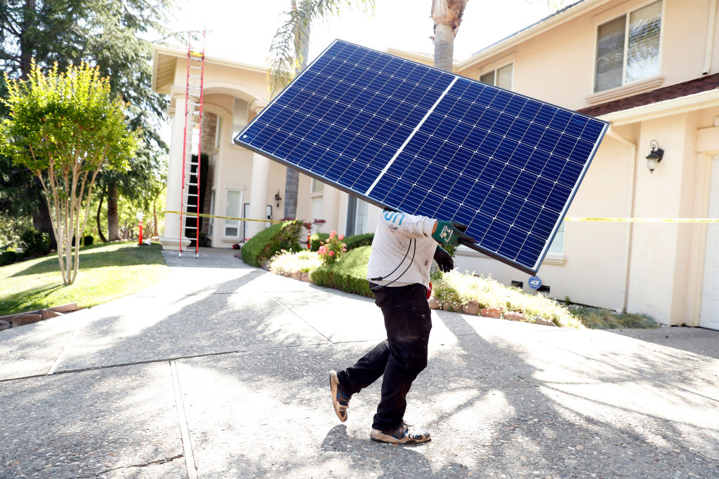 Sunrun employee Gonzalo Najera carries a solar panel before installation at a home in Alamo, Calif. (Scott Strazzante/San Francisco Chronicle via Getty Images))